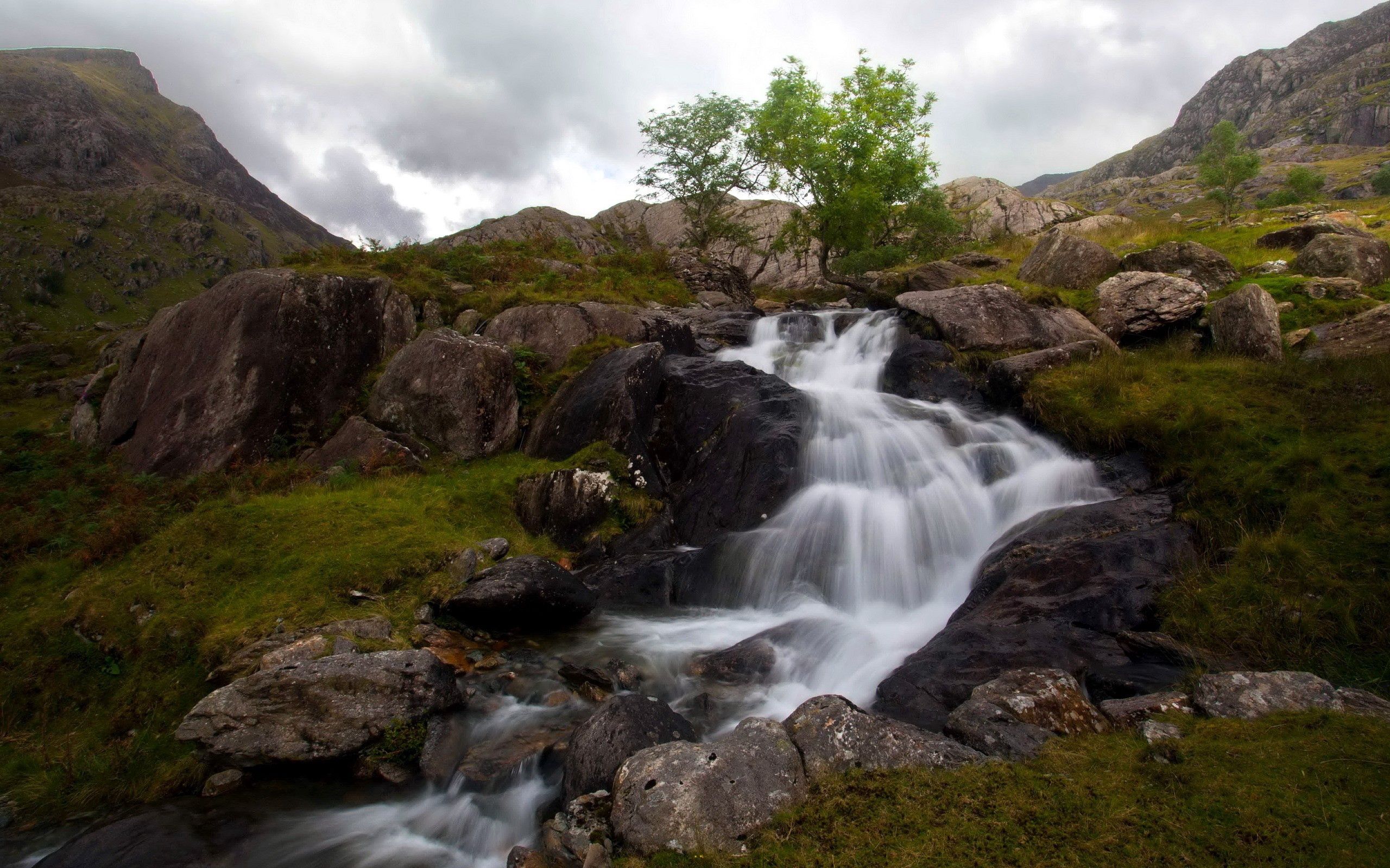 Download mobile wallpaper Grass, Waterfall, Stones, Mountains, Nature for free.