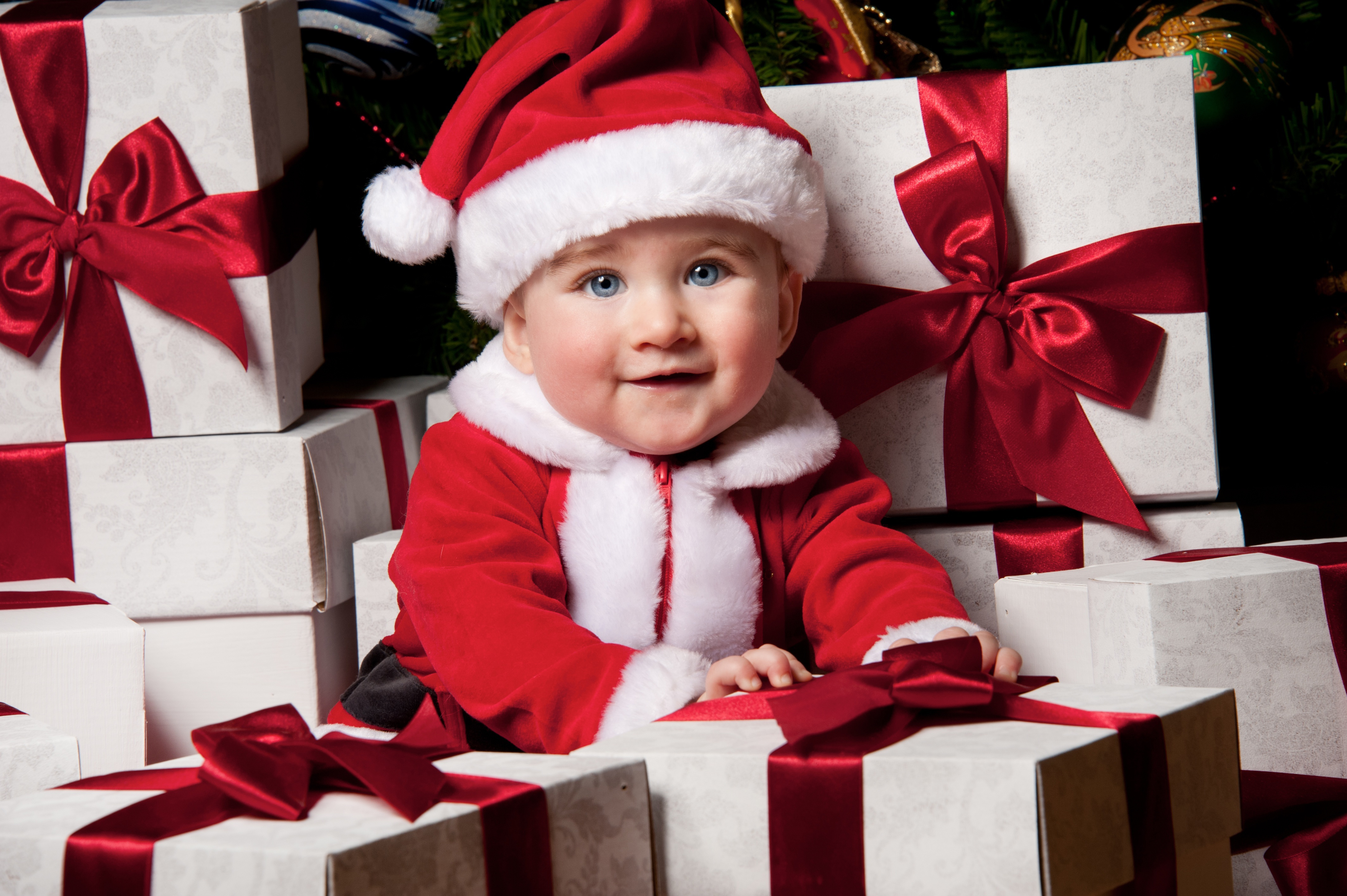 Скачати мобільні шпалери Різдво, Милий, Подарунок, Дитина, Фотографія, Блакитні Очі, Посміхніться, Капелюх Діда Мороза безкоштовно.
