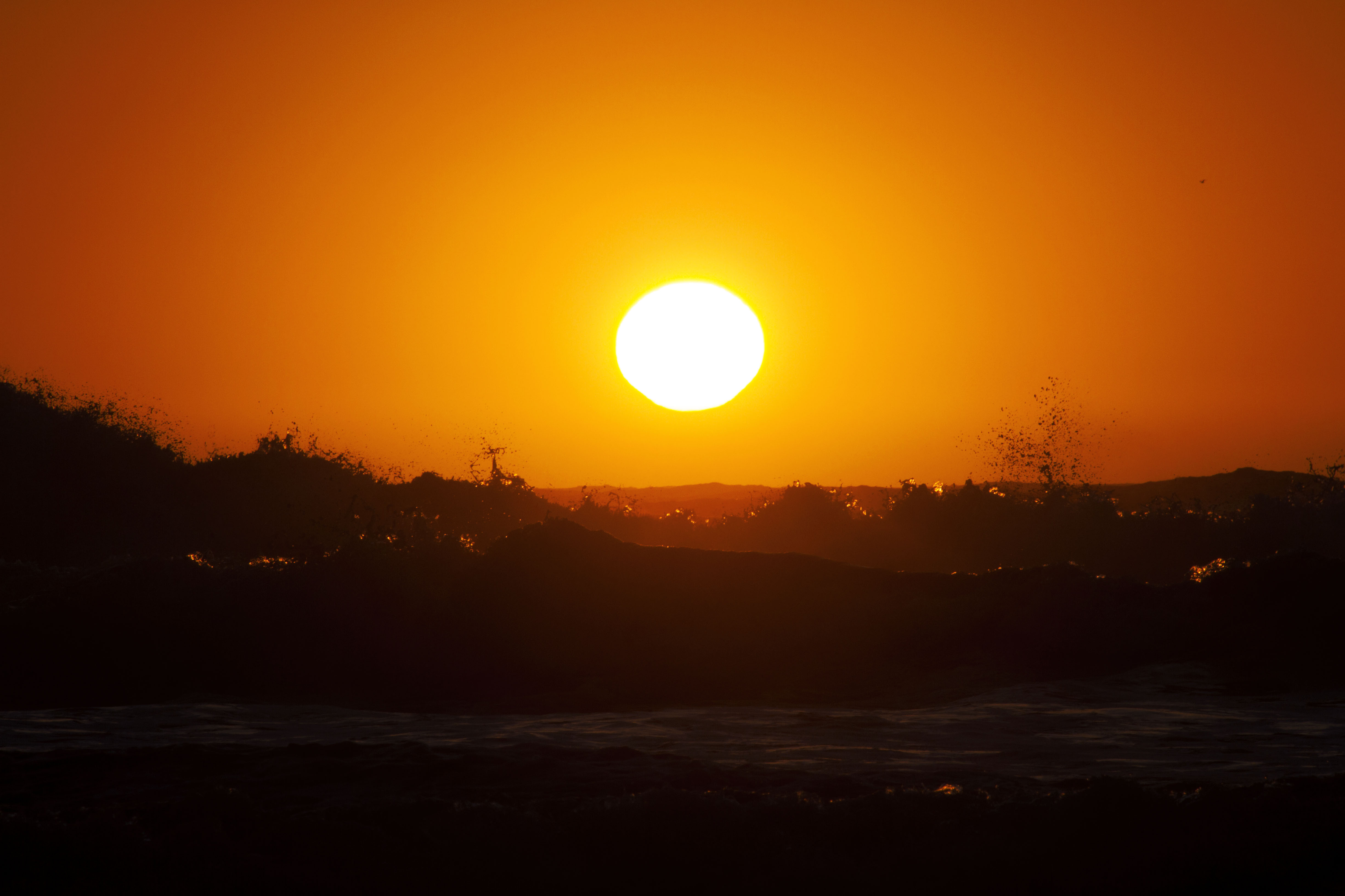 Download mobile wallpaper Sunset, Sun, Ocean, Earth, Glow, Wave for free.