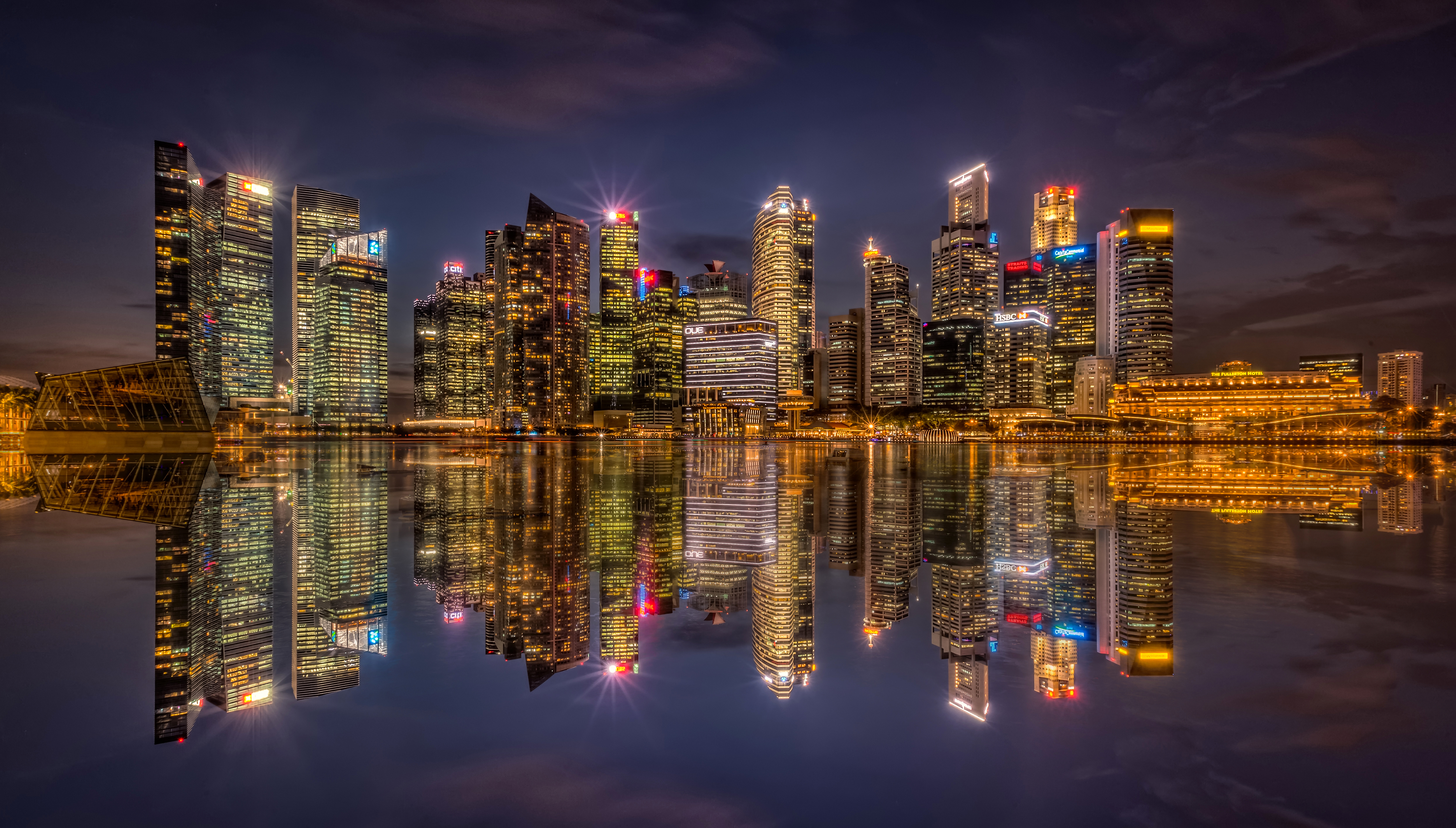 Скачать картинку Города, Ночь, Город, Отражение, Свет, Здание, Сингапур, Небоскрёб, Сделано Человеком в телефон бесплатно.