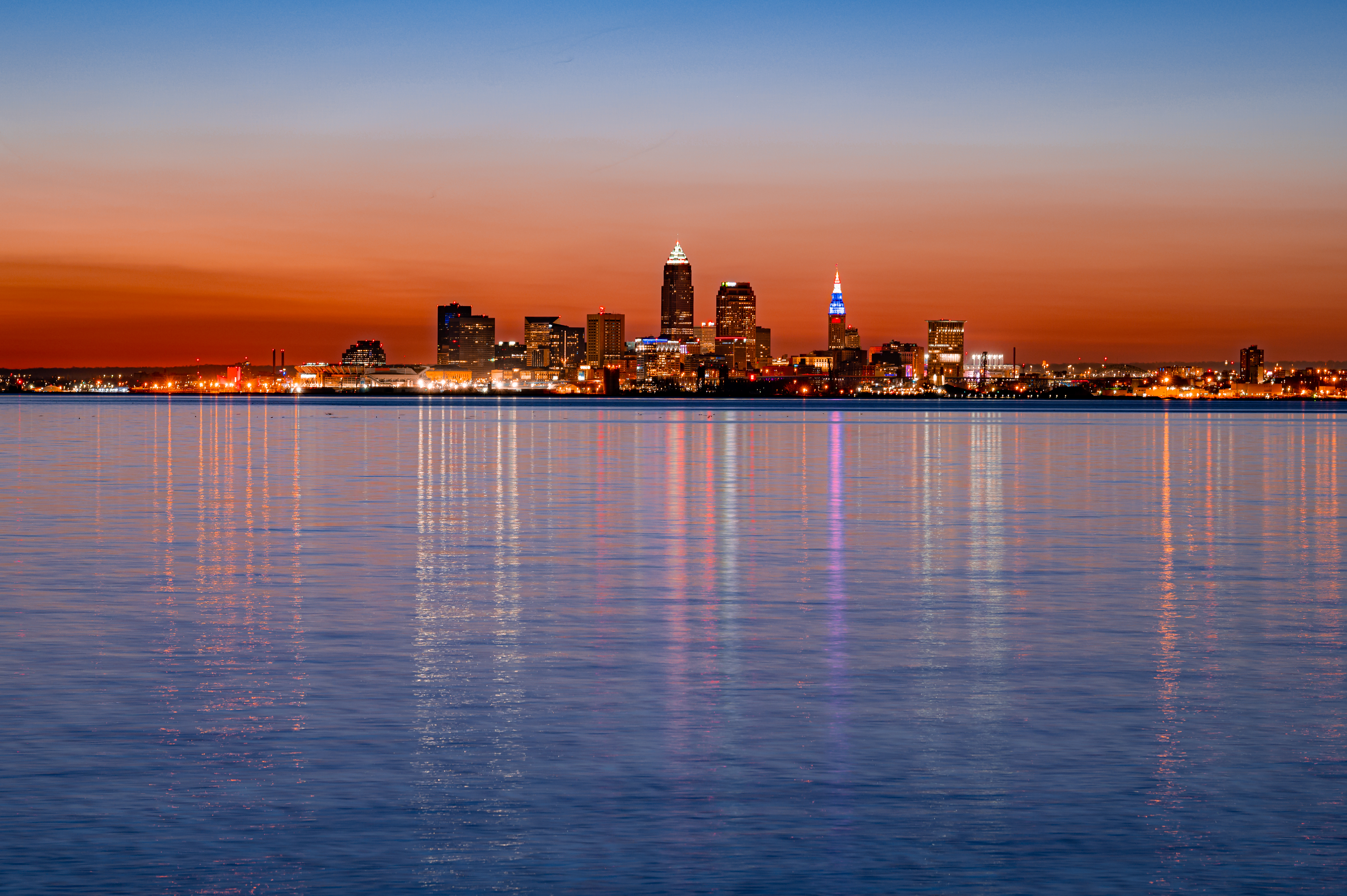 Download mobile wallpaper Cities, Reflection, Sunset, Lights, City, Building, Water for free.