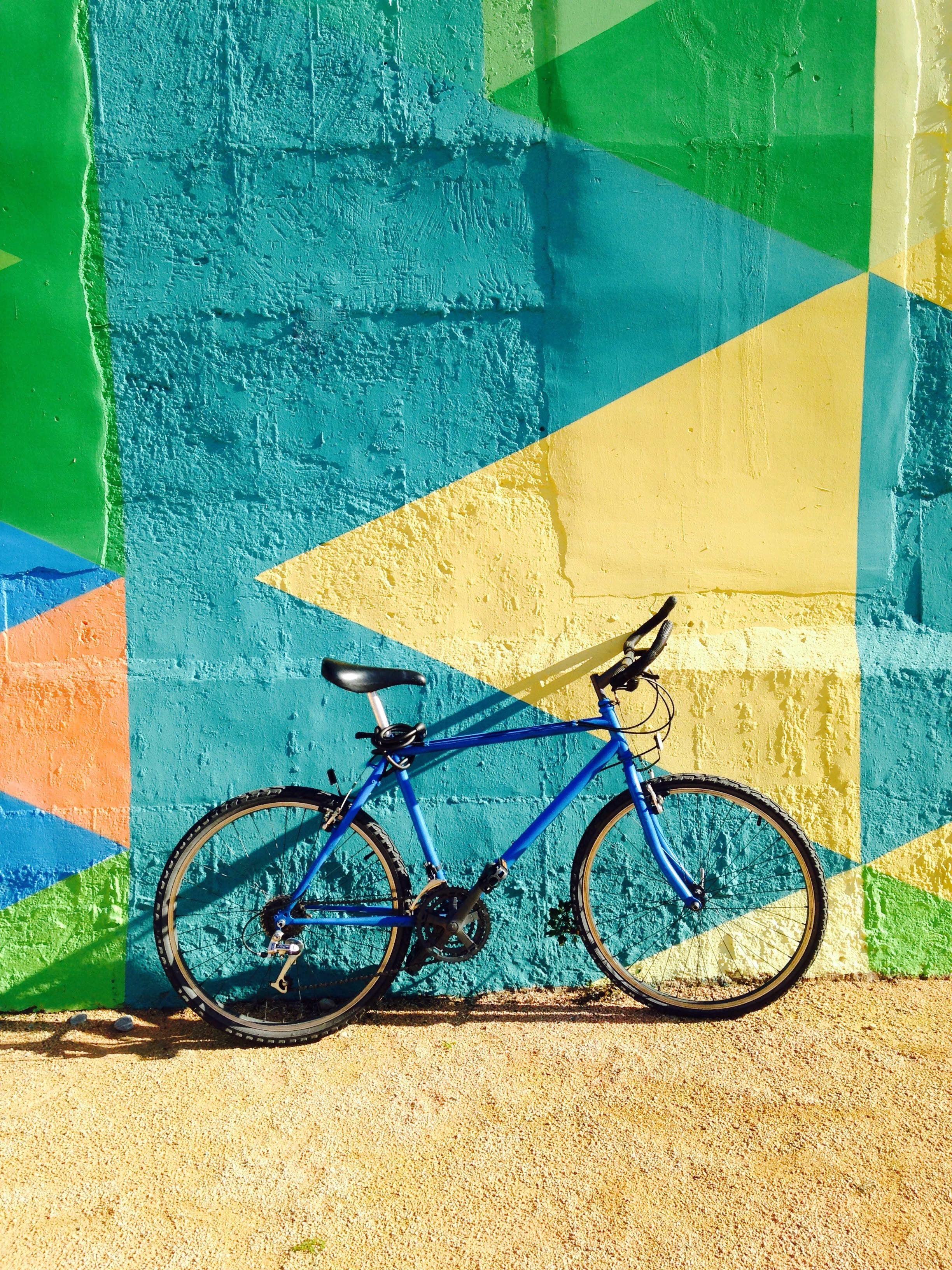 122908 скачать картинку разноцветный, стена, солнечный свет, велосипед, разное, тень, красочный - обои и заставки бесплатно