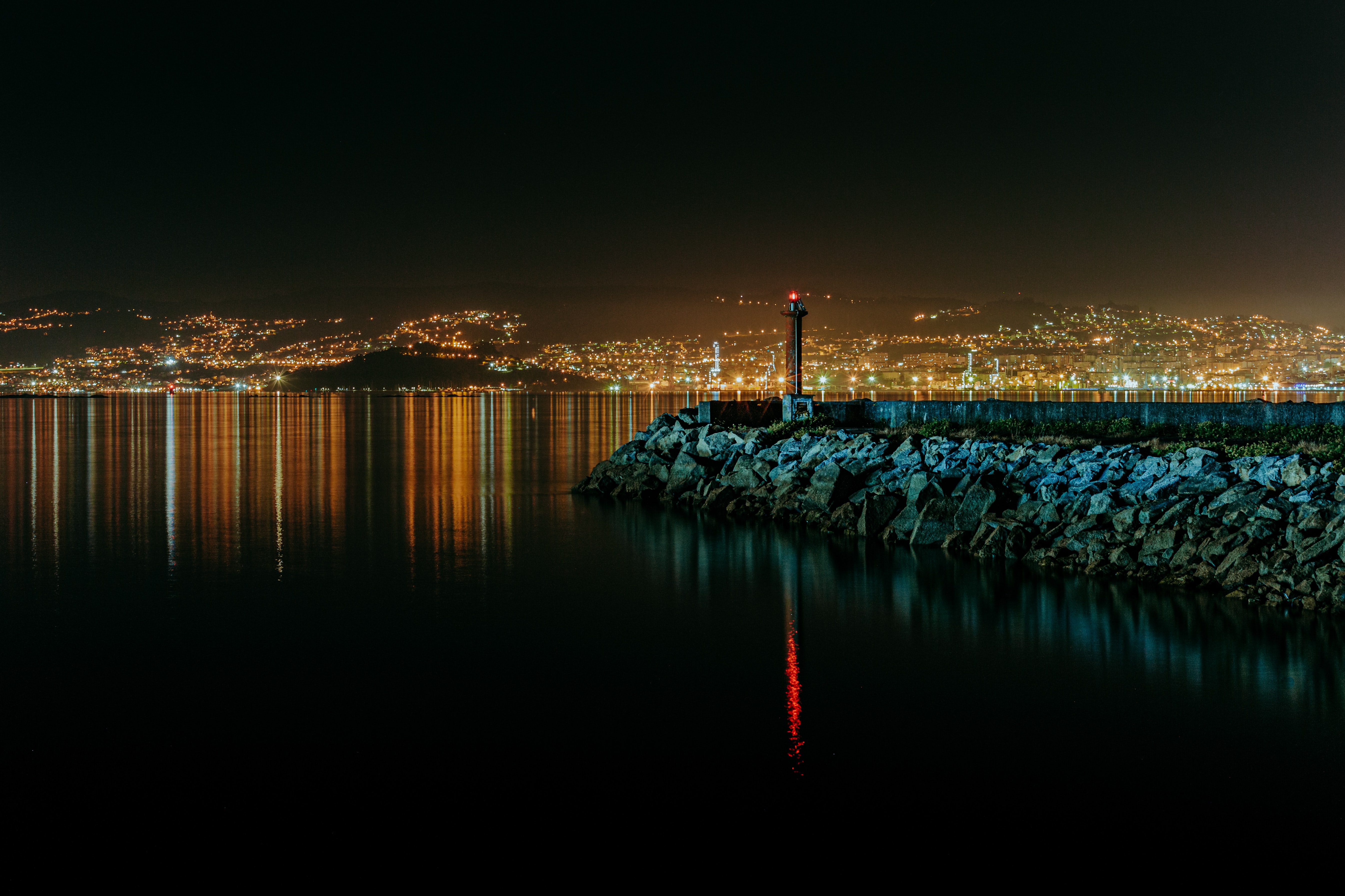 Free download wallpaper Nature, Water, Stones, Night, Lighthouse, City on your PC desktop
