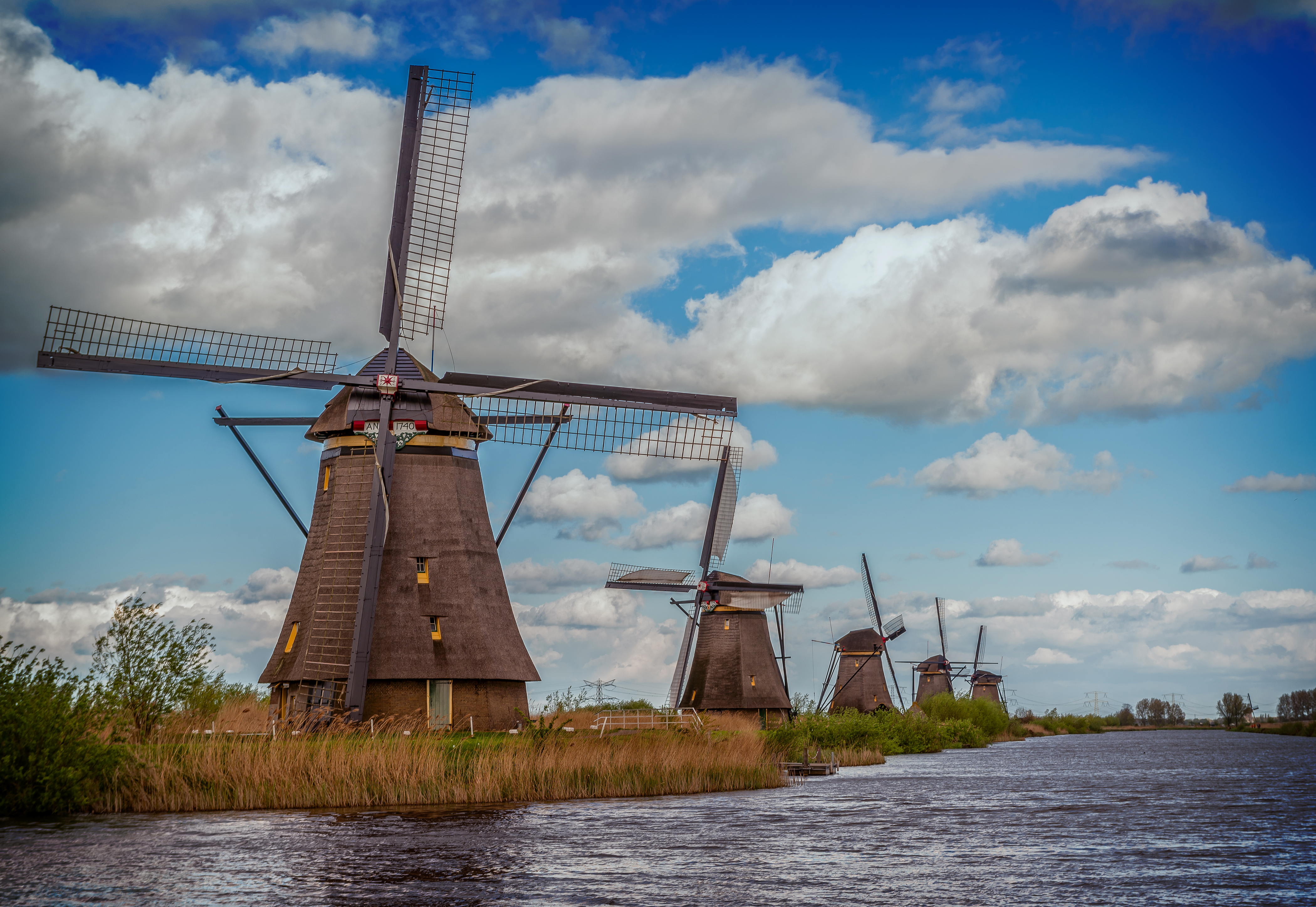 Download mobile wallpaper Sky, Building, Cloud, River, Netherlands, Windmill, Man Made for free.