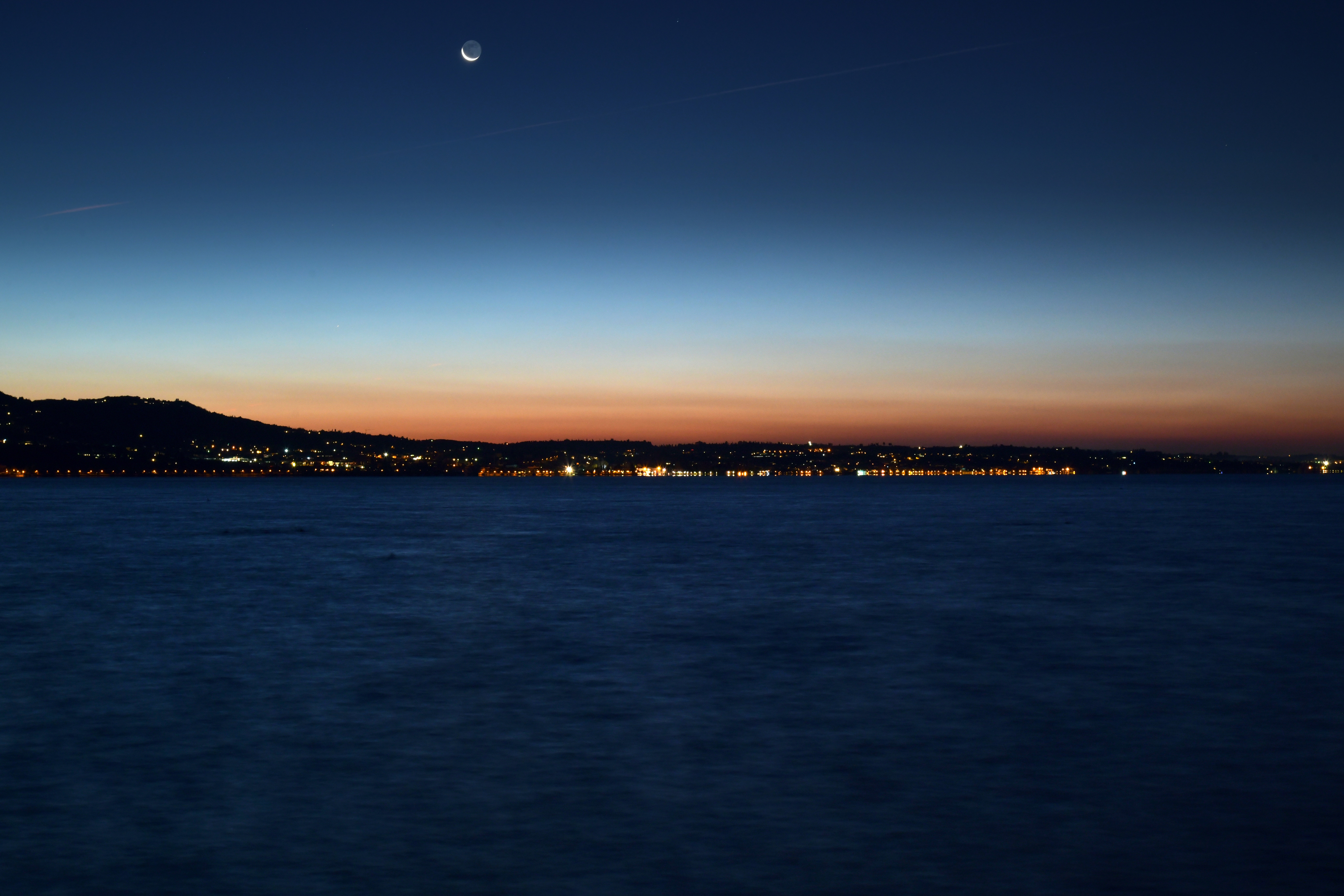Download mobile wallpaper Shore, Cities, Bank, Sea, Sunset, Horizon, Night City, Night for free.