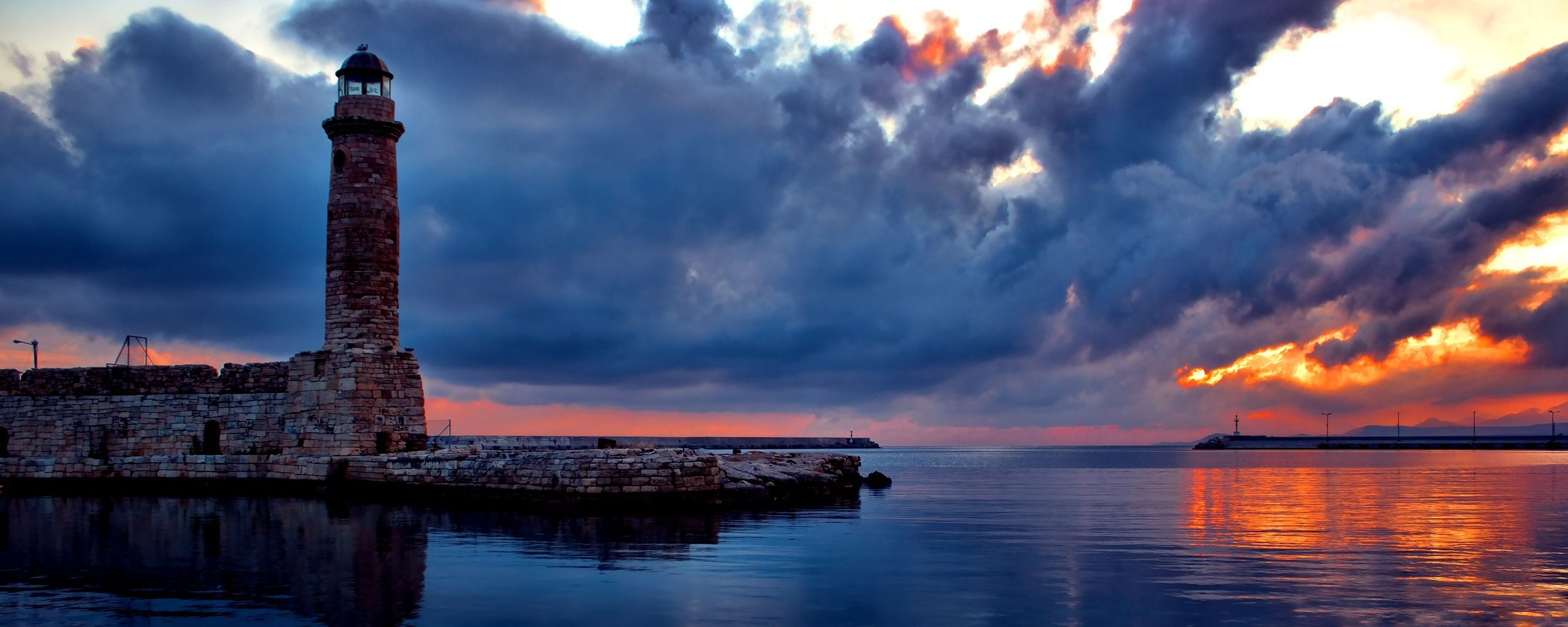 Download mobile wallpaper Sunset, Sky, Sea, Horizon, Ocean, Lighthouse, Cloud, Man Made for free.