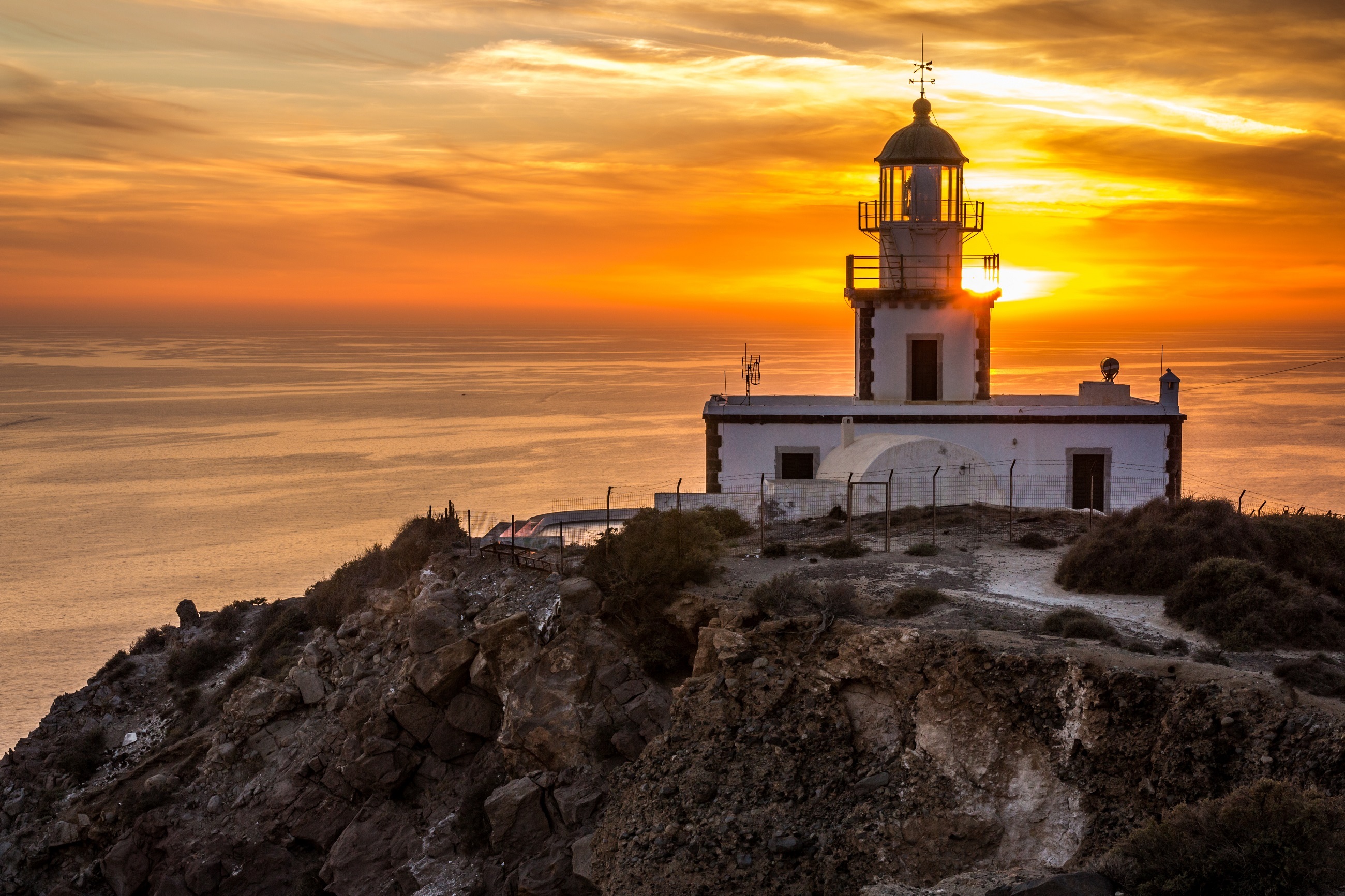 Download mobile wallpaper Sunset, Building, Lighthouse, Greece, Man Made for free.