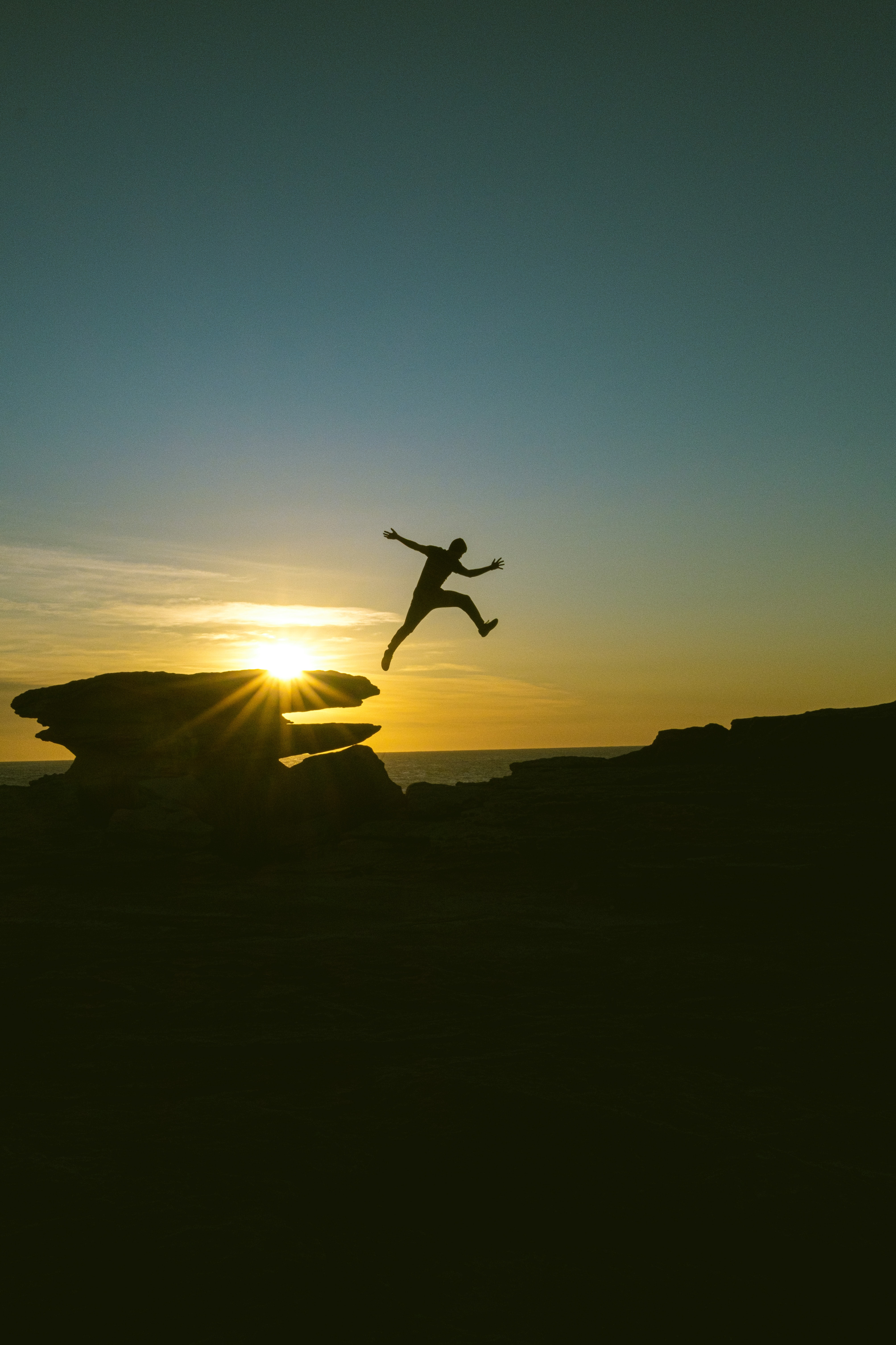 person, human, dark, sunset, rocks, bounce, jump cell phone wallpapers