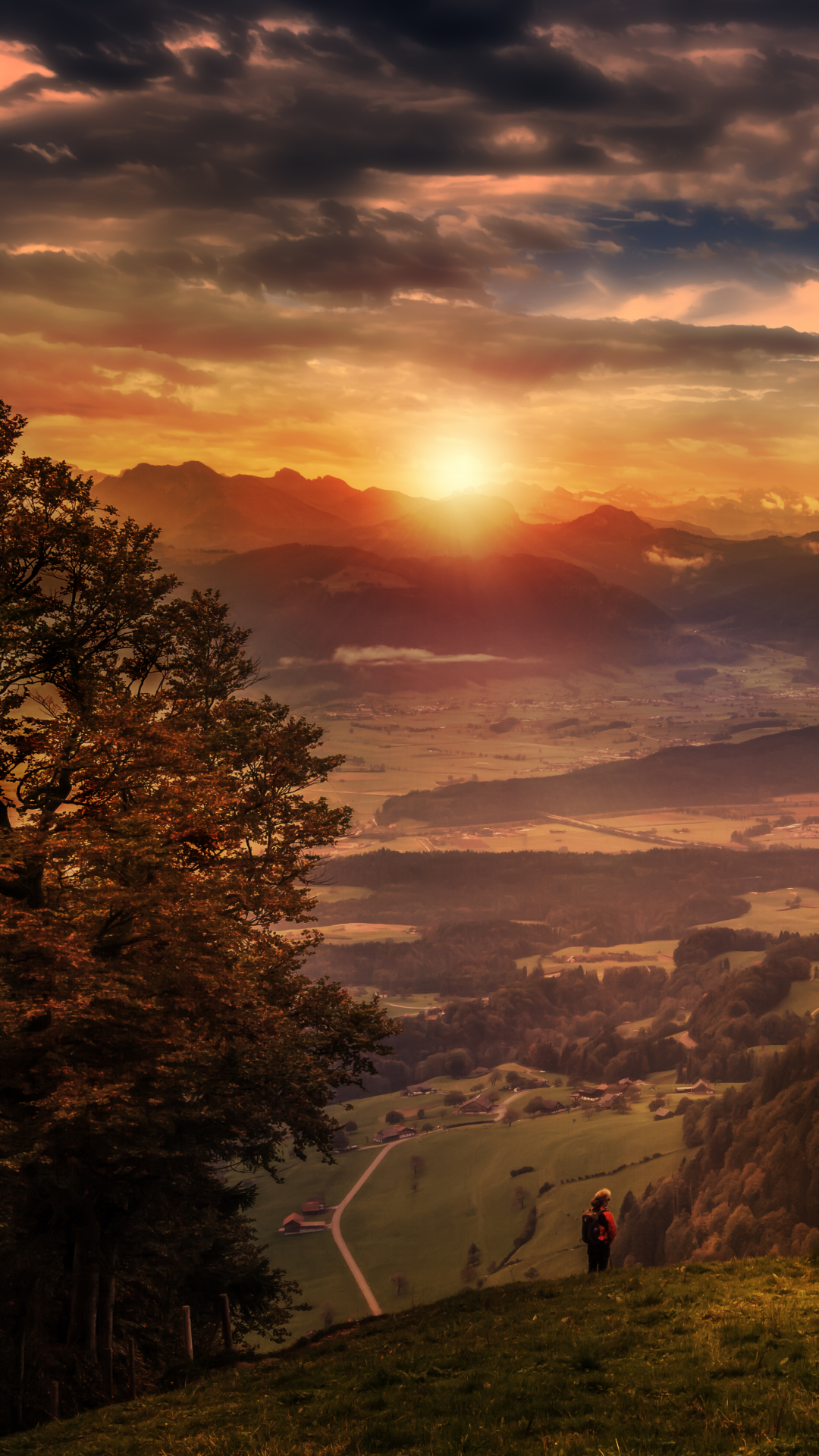 Download mobile wallpaper Landscape, Sunset, Sun, Mountain, Lake, Earth, Evening, Switzerland, Hill, Valley, Cloud for free.