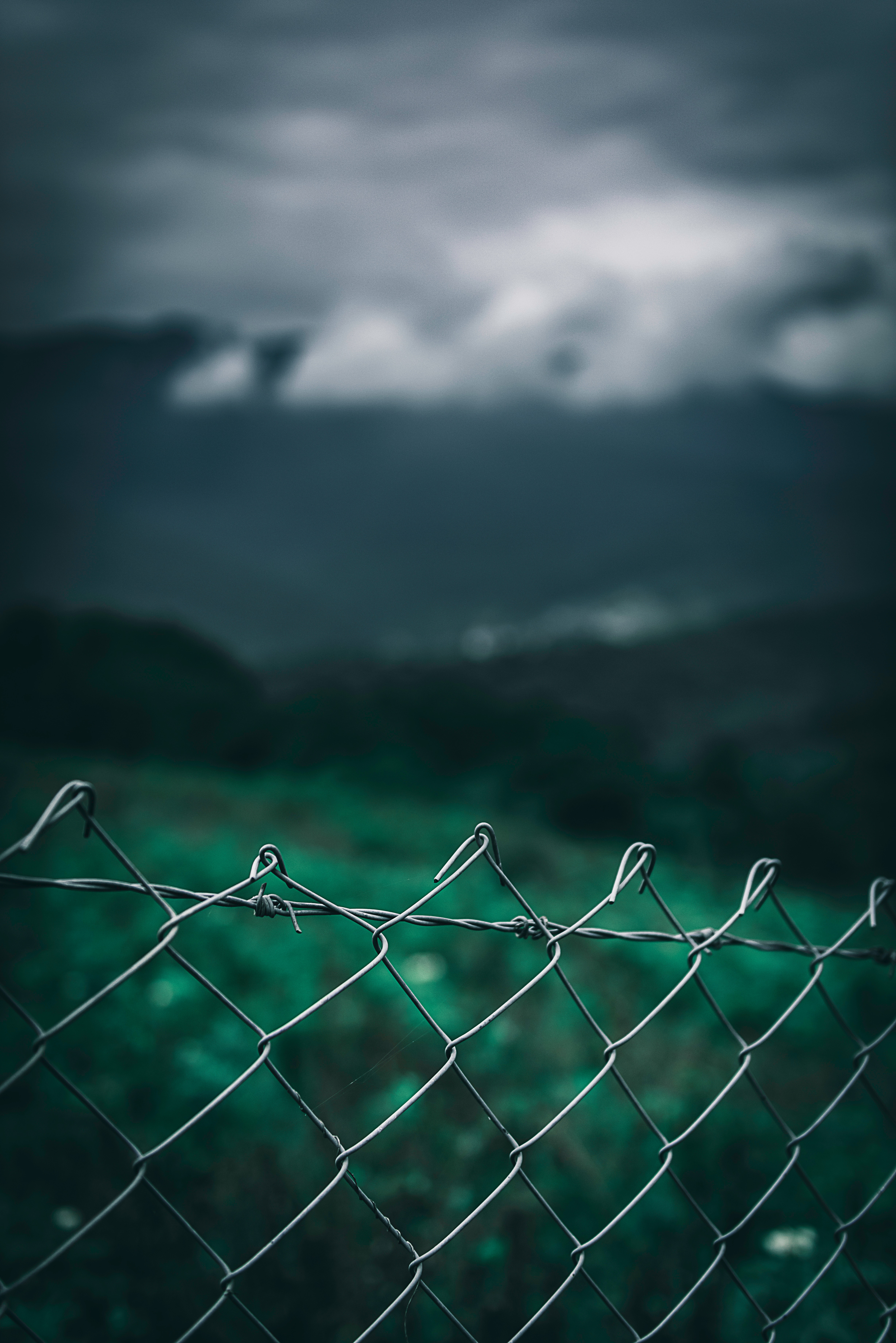 Download mobile wallpaper Clouds, Sky, Fence, Miscellaneous, Miscellanea, Smooth, Grass, Grid, Blur for free.