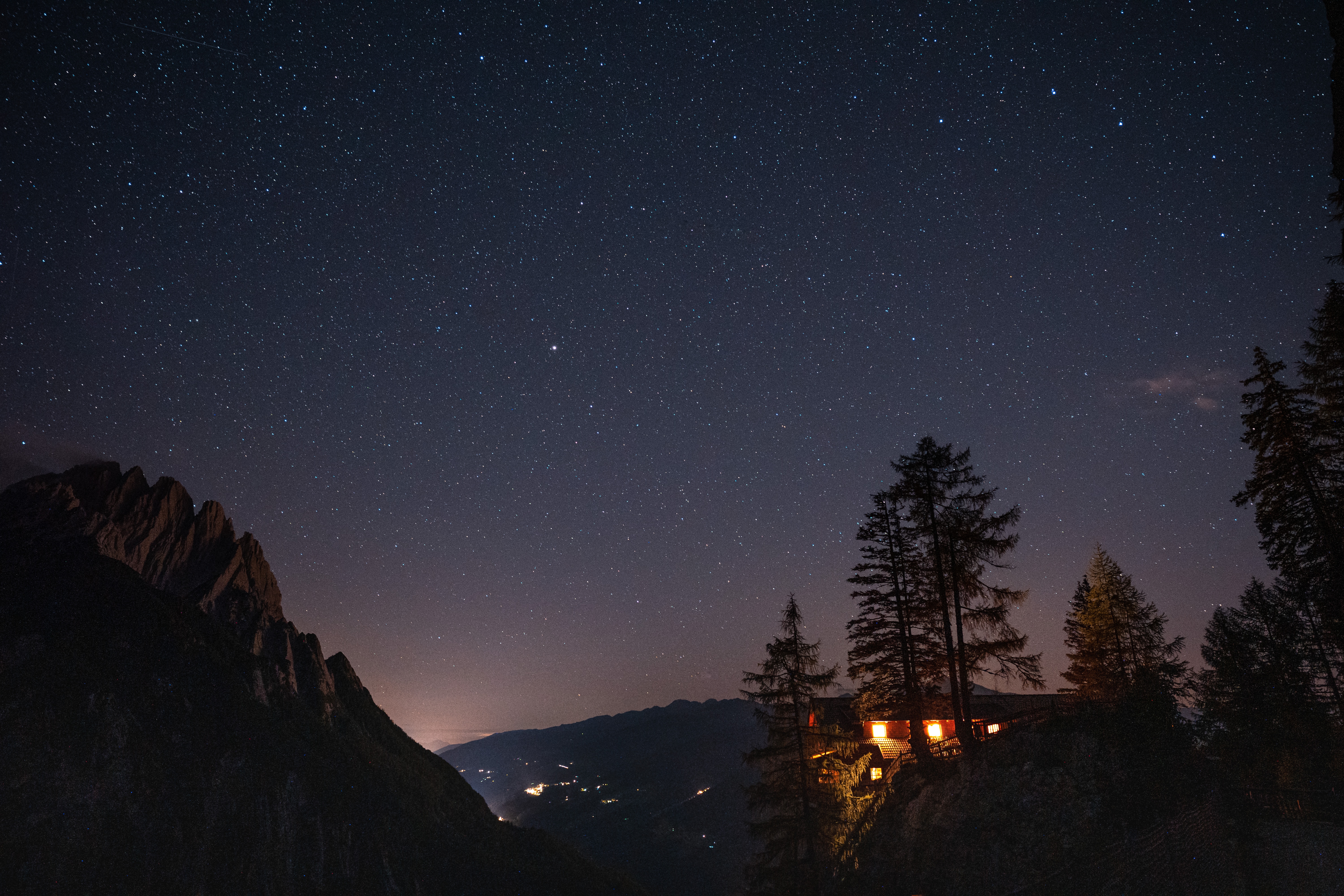 Download mobile wallpaper Cliff, Mountains, House, Starry Sky, Night, Shine, Dark, Light for free.