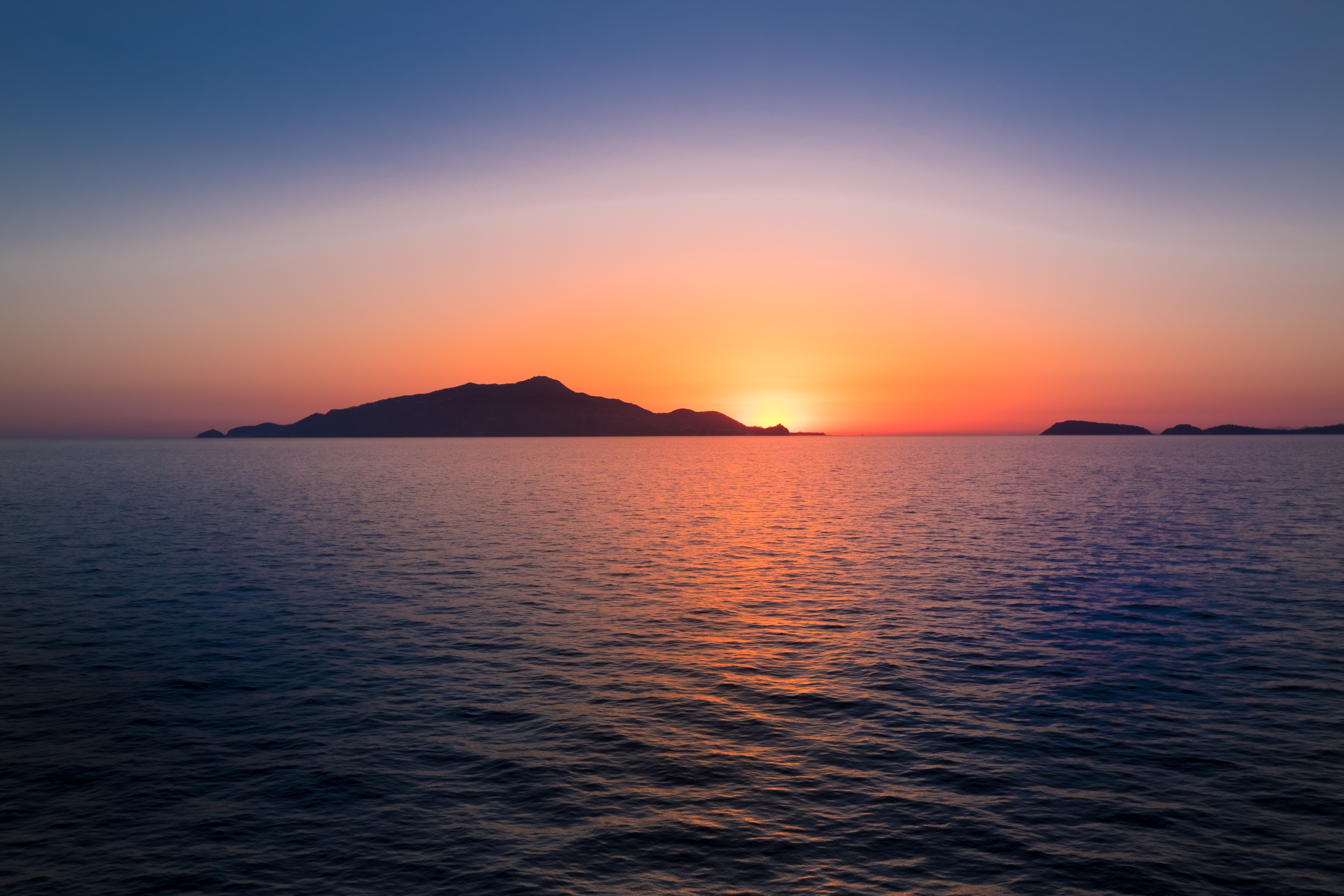 Download mobile wallpaper Sea, Sky, Glare, Nature, Sunset, Hills for free.