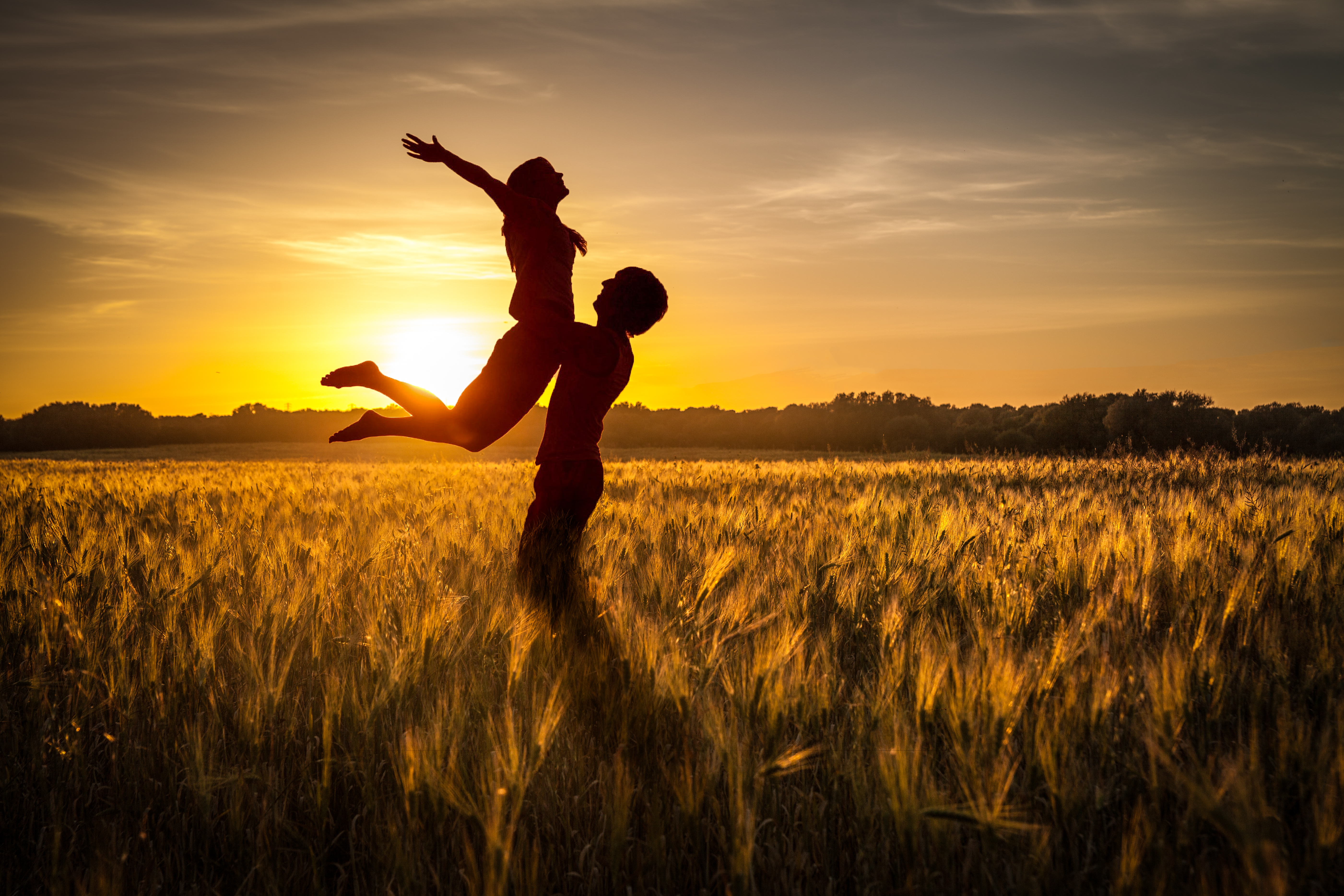 Download mobile wallpaper Field, Sunset, Silhouettes, Grass, Couple, Love, Pair for free.