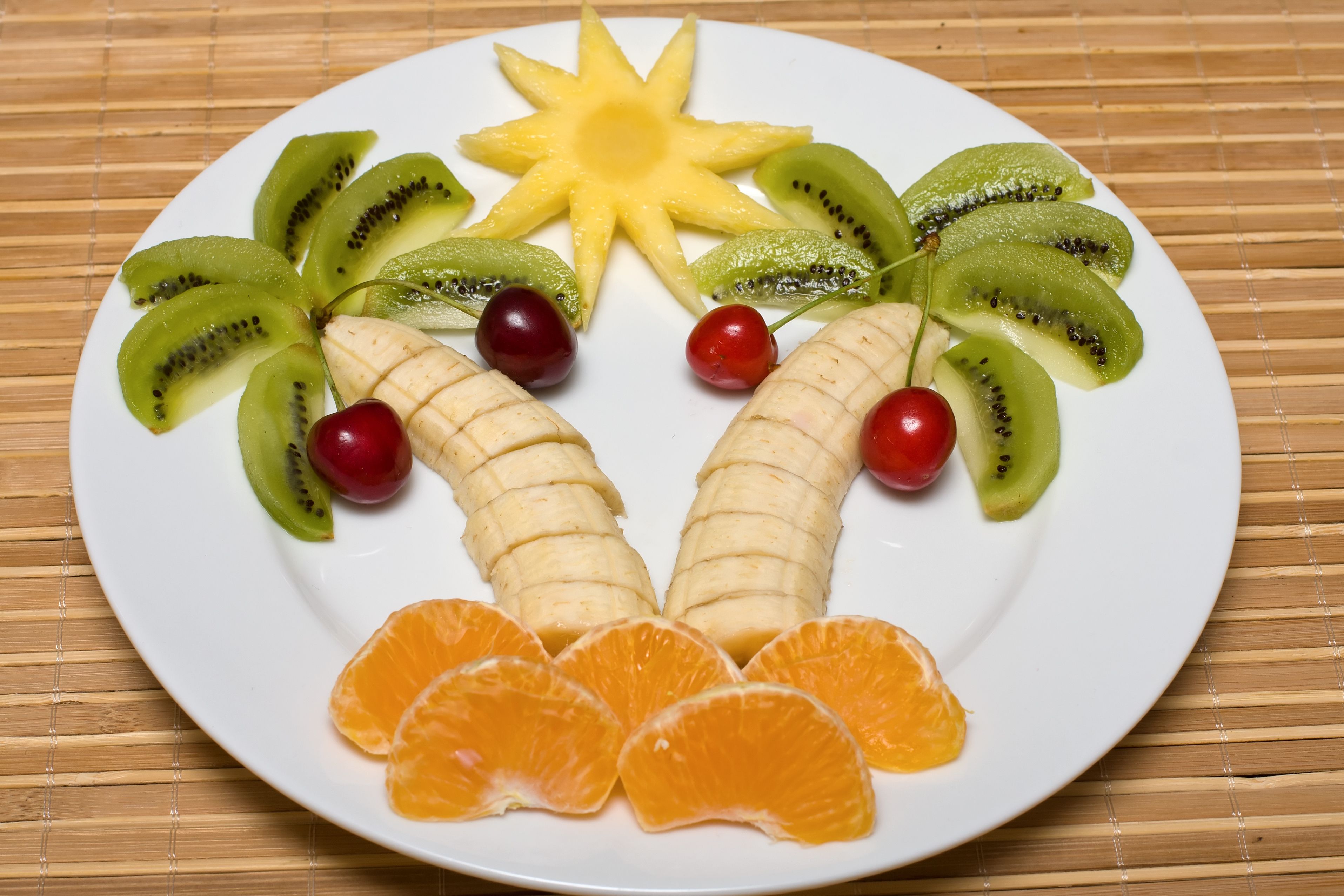 377528 завантажити картинку харчування, фрукти, банан, вишня, ківі, мандарин, тарілка - шпалери і заставки безкоштовно