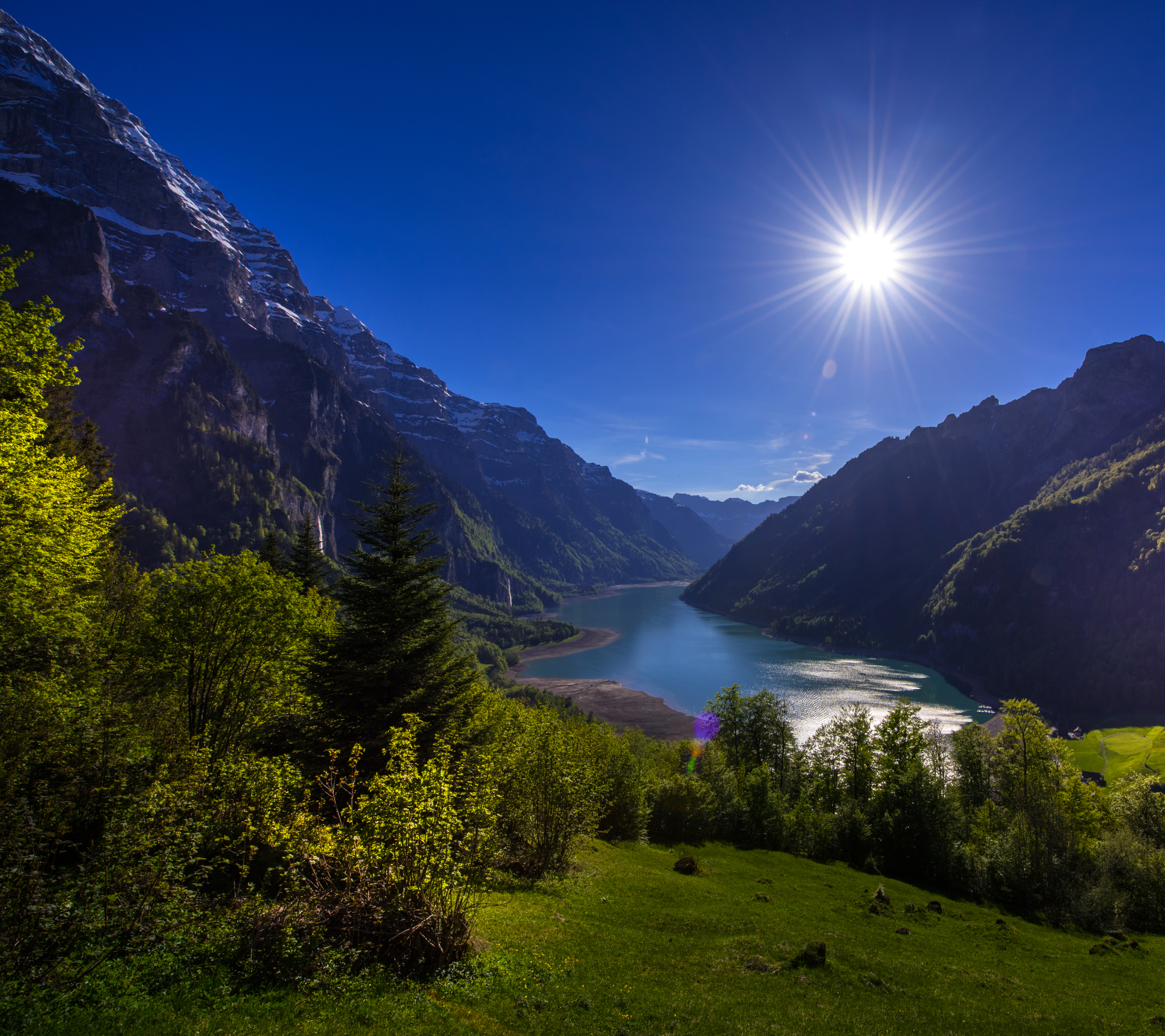 Скачать картинку Пейзаж, Солнце, Гора, Озеро, Швейцария, Земля/природа в телефон бесплатно.