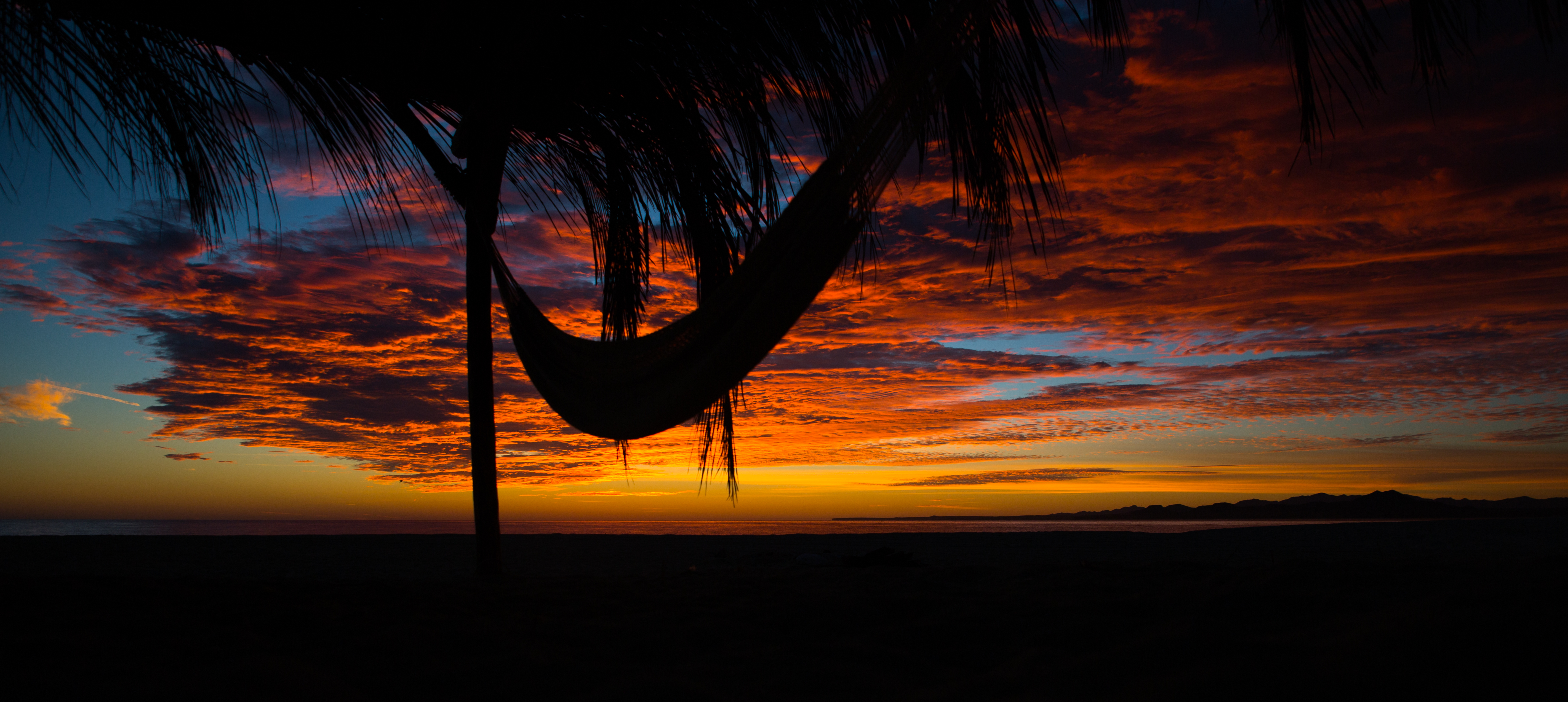 Download mobile wallpaper Hammock, Clouds, Sunset, Palm, Dark for free.