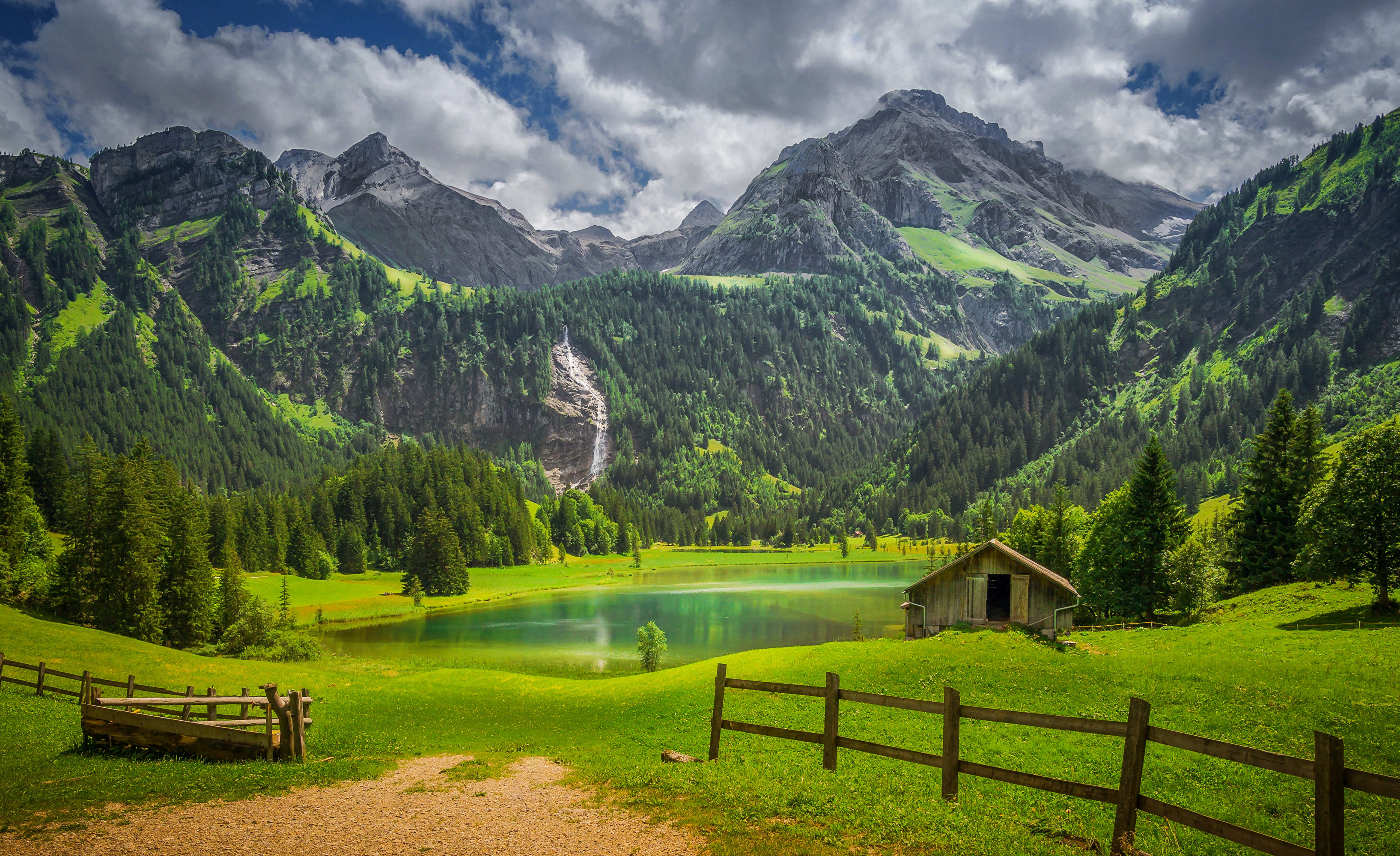 Скачать картинку Озера, Озеро, Водопад, Лес, Альпы, Ограда, Швейцария, Фотографии в телефон бесплатно.