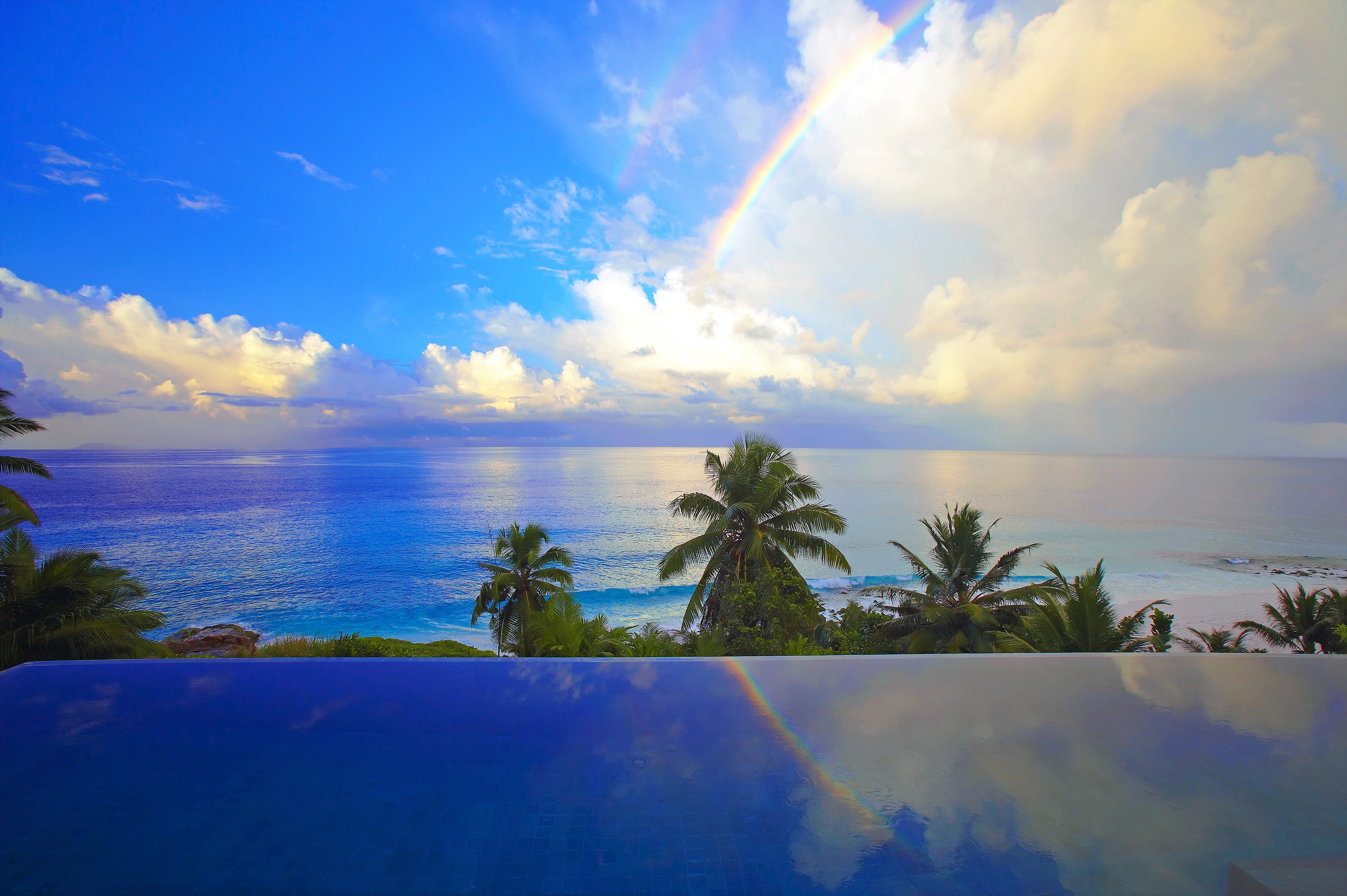 Download mobile wallpaper Sky, Sea, Rainbow, Horizon, Ocean, Earth, Tropical, Cloud, Palm Tree for free.