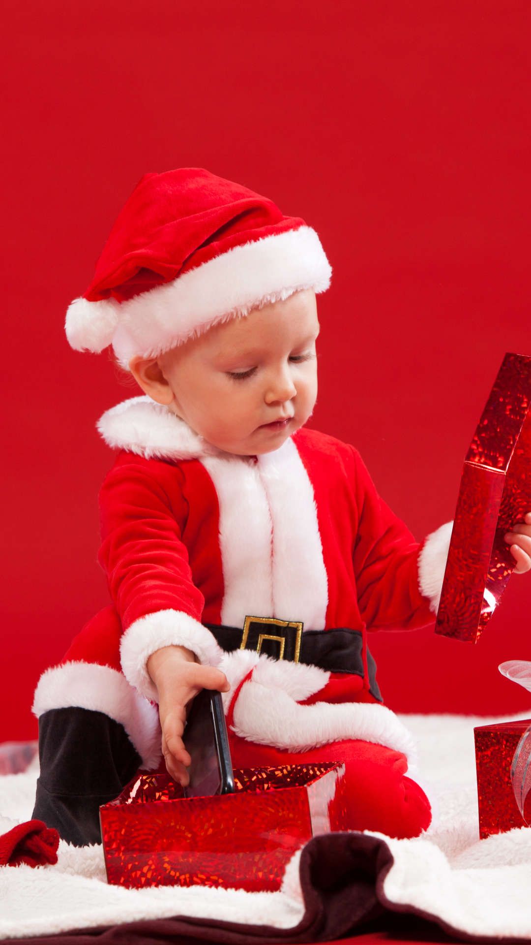 Скачать картинку Красный, Рождество, Подарок, Малыш, Фотографии, Подарки, Шляпа Санты в телефон бесплатно.