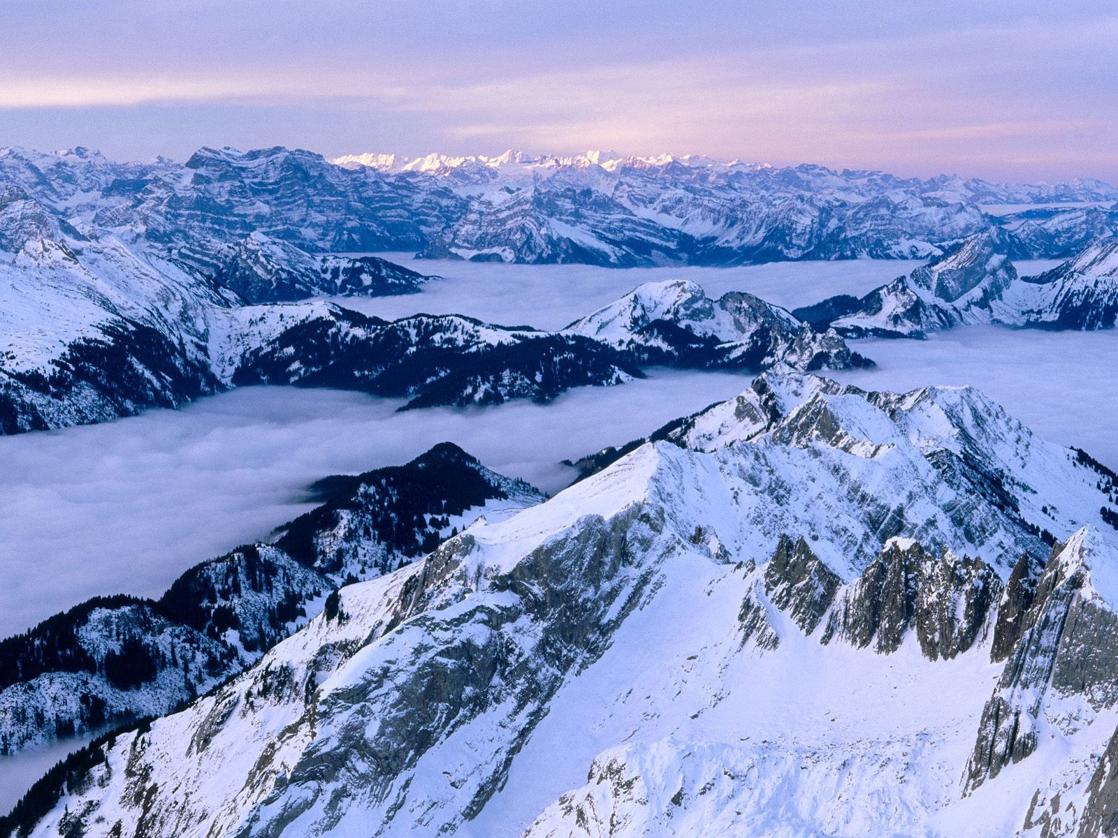 Скачать картинку Туман, Снег, Вершины, Горы, Швейцария, Природа в телефон бесплатно.