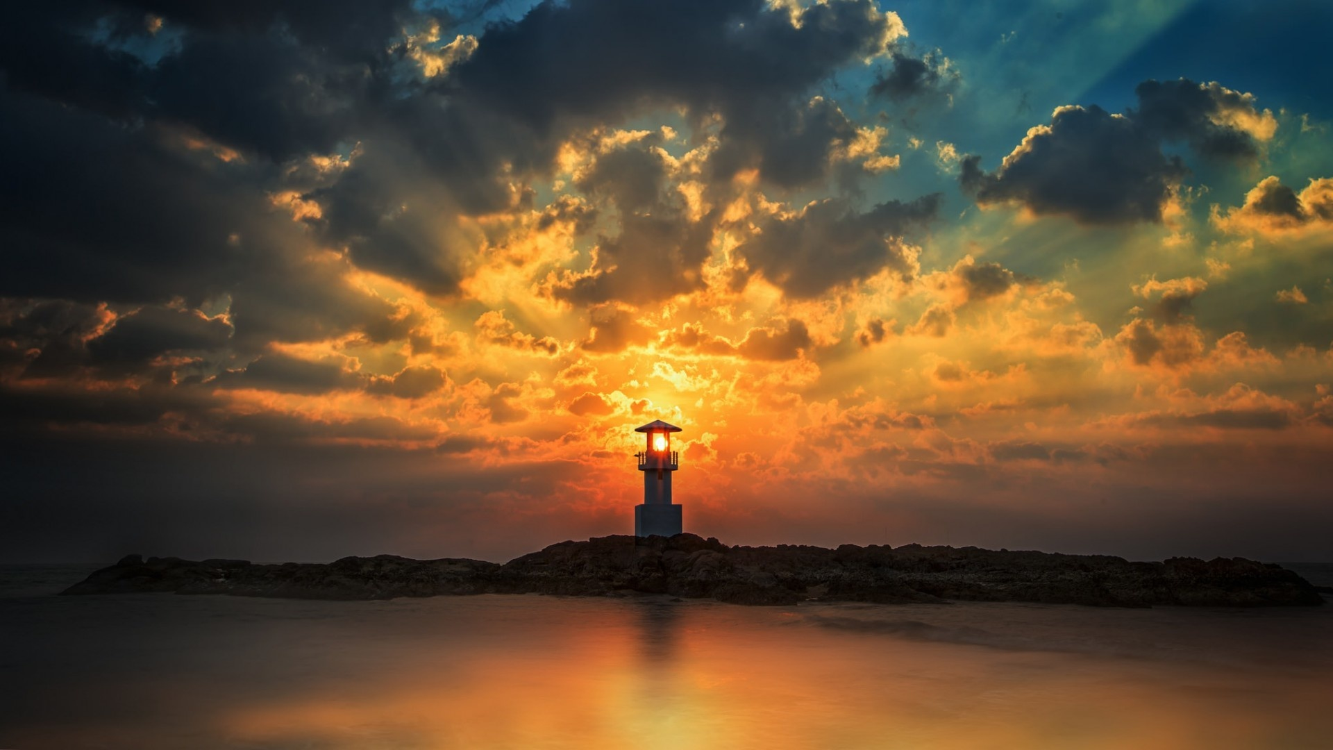 Download mobile wallpaper Sunset, Sea, Building, Ocean, Lighthouse, Cloud, Sunbeam, Man Made for free.