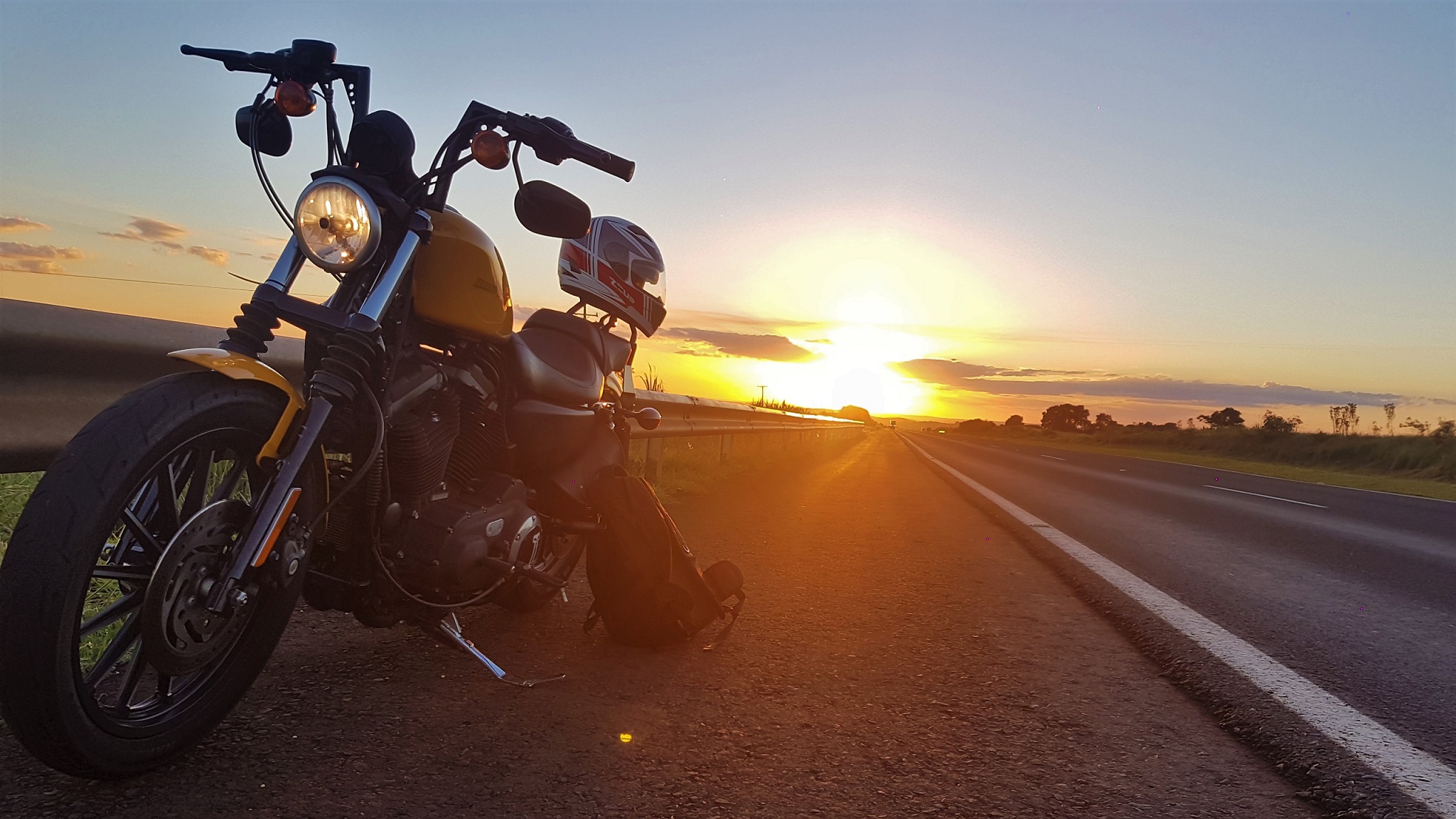 Download mobile wallpaper Sunset, Sun, Motorcycles, Road, Helmet, Motorcycle, Harley Davidson, Vehicles for free.