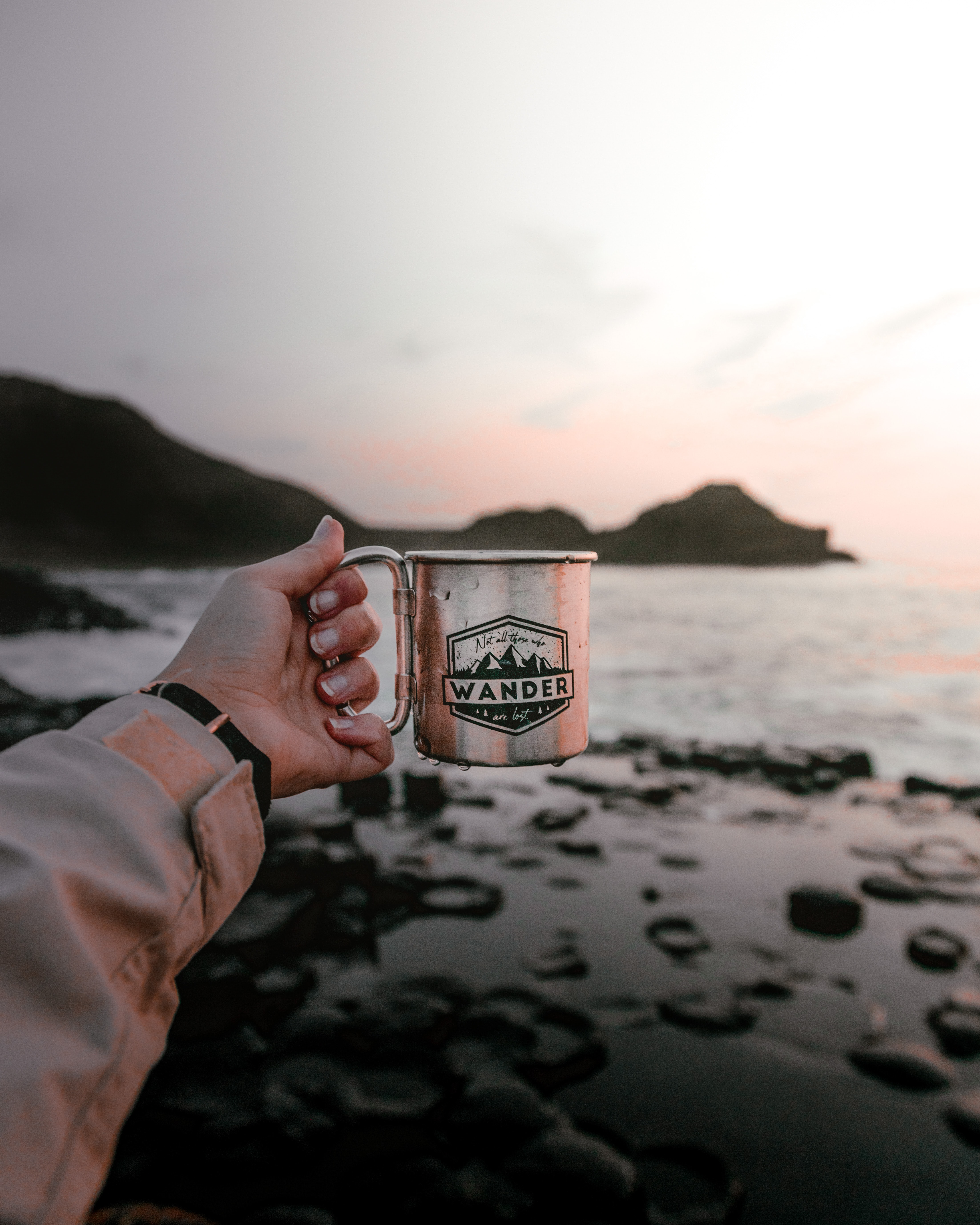 Free download wallpaper Water, Sunset, Rocks, Miscellanea, Miscellaneous, Mug, Hand, Cup on your PC desktop