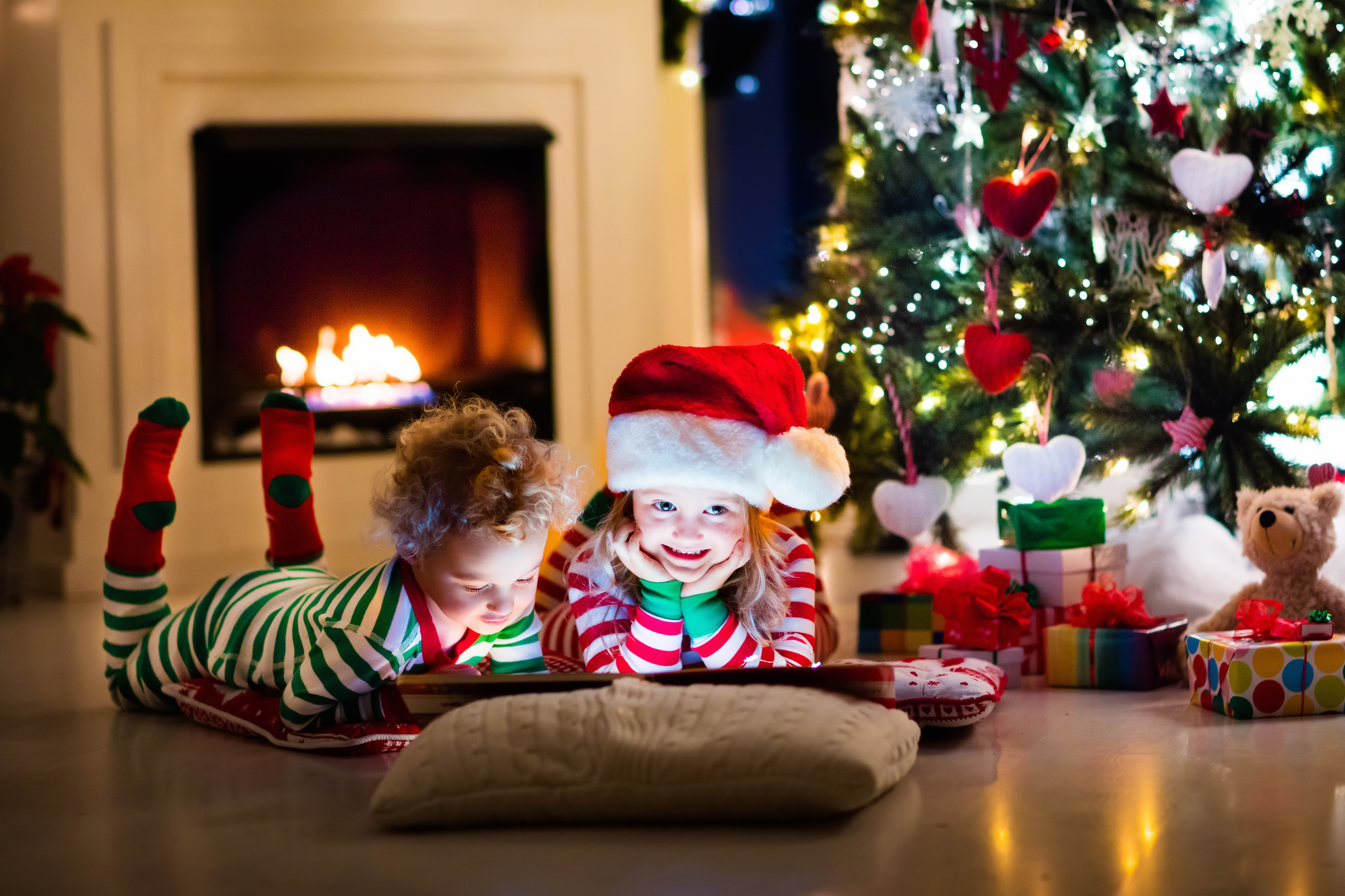 Скачать картинку Рождество, Ребенок, Камин, Фотографии, Подарки, Шляпа Санты в телефон бесплатно.