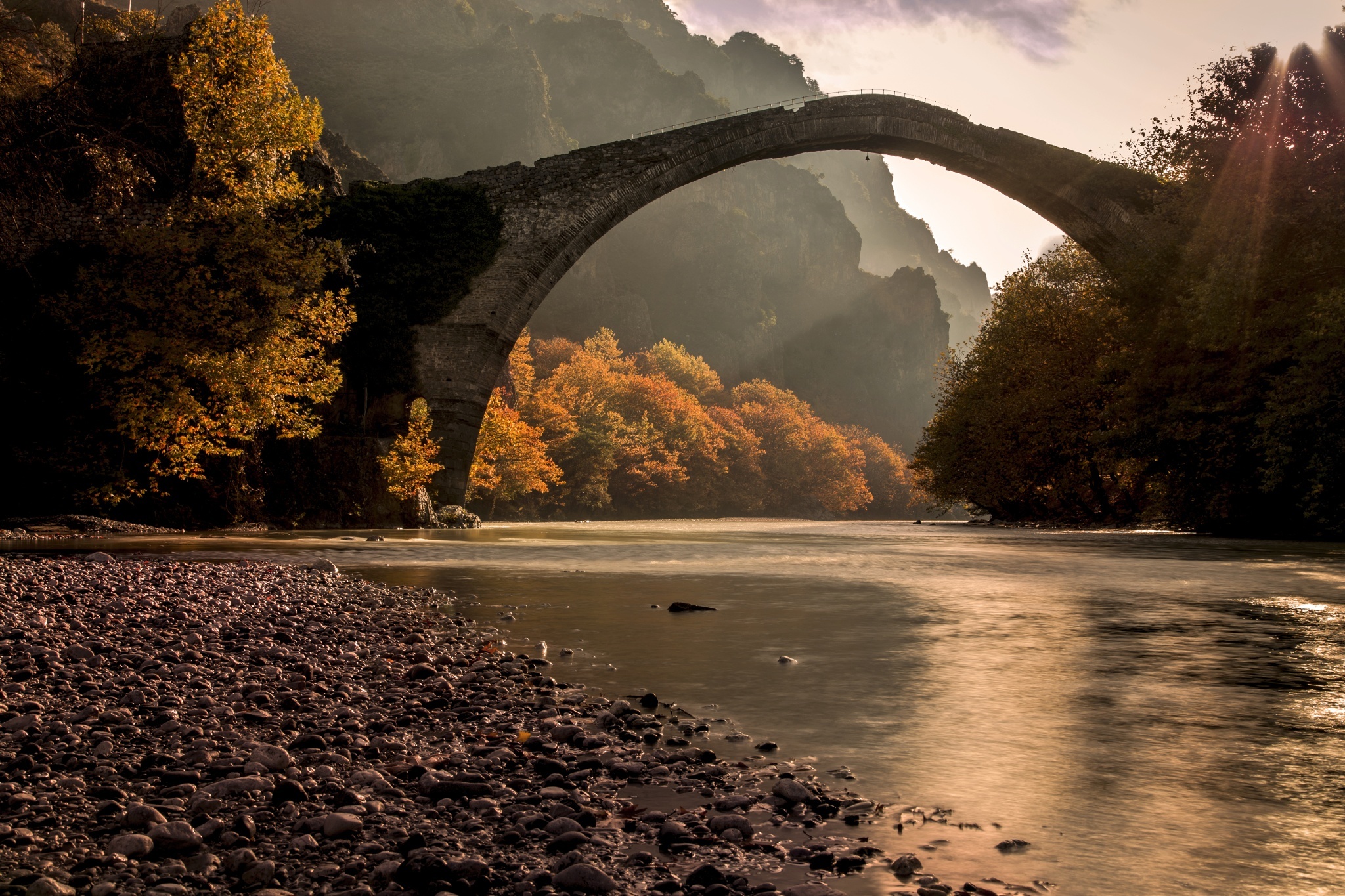 Handy-Wallpaper Fluss, Brücke, Stein, Sonnenstrahl, Brücken, Menschengemacht kostenlos herunterladen.