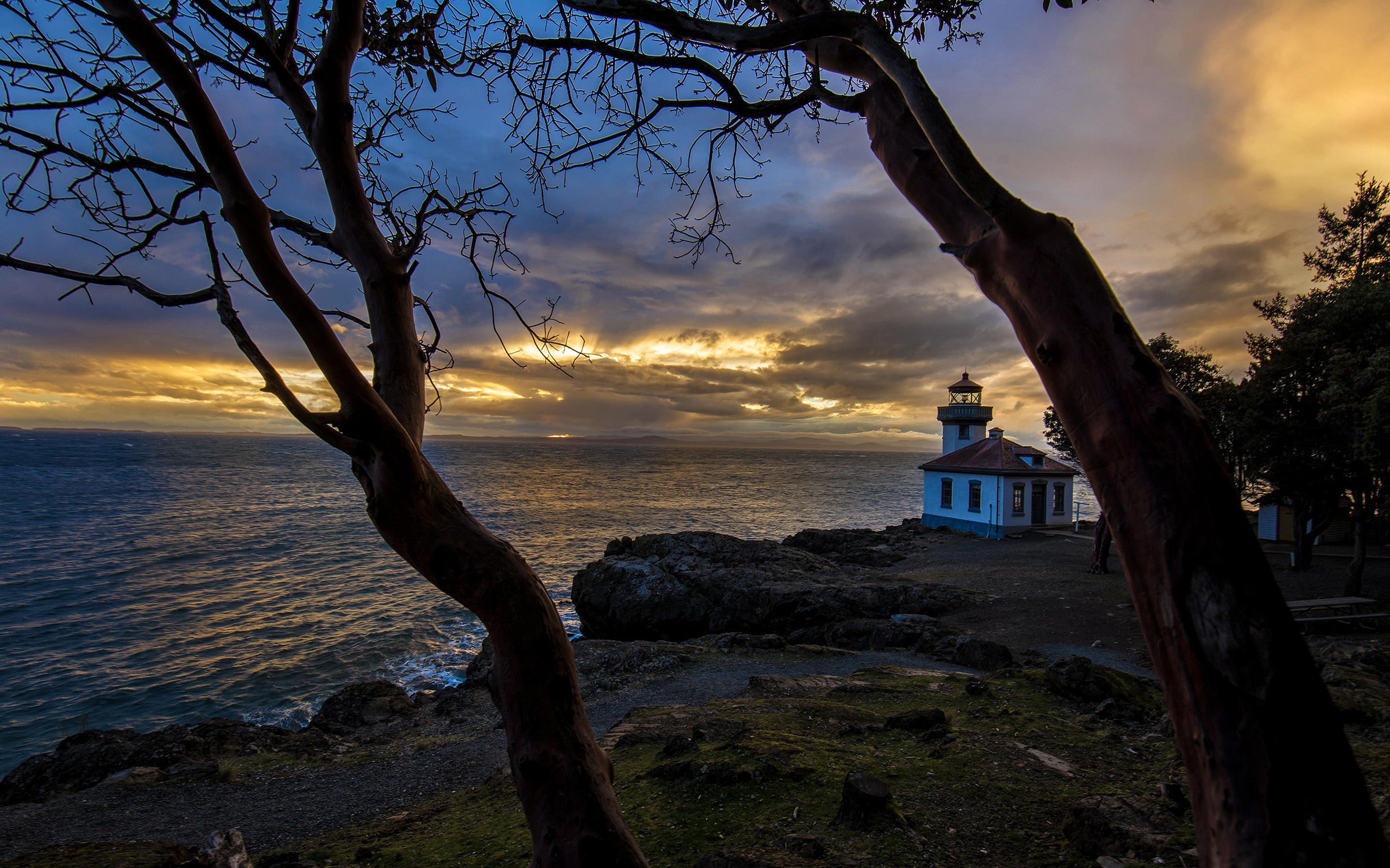 Download mobile wallpaper Sunset, Sky, Horizon, Coast, Tree, Lighthouse, Cloud, Man Made for free.