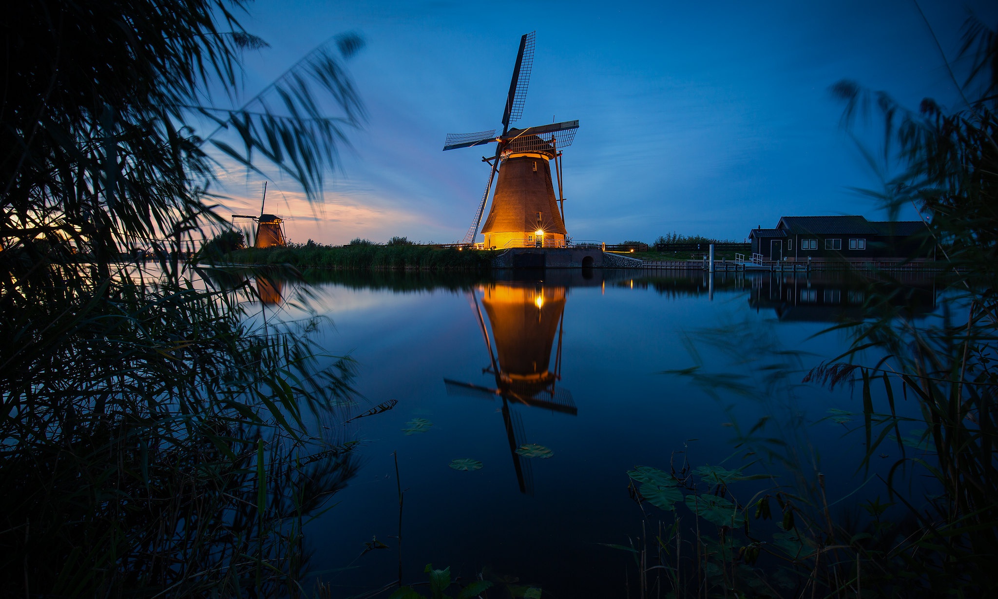 Download mobile wallpaper Night, Building, Reflection, River, Windmill, Man Made for free.