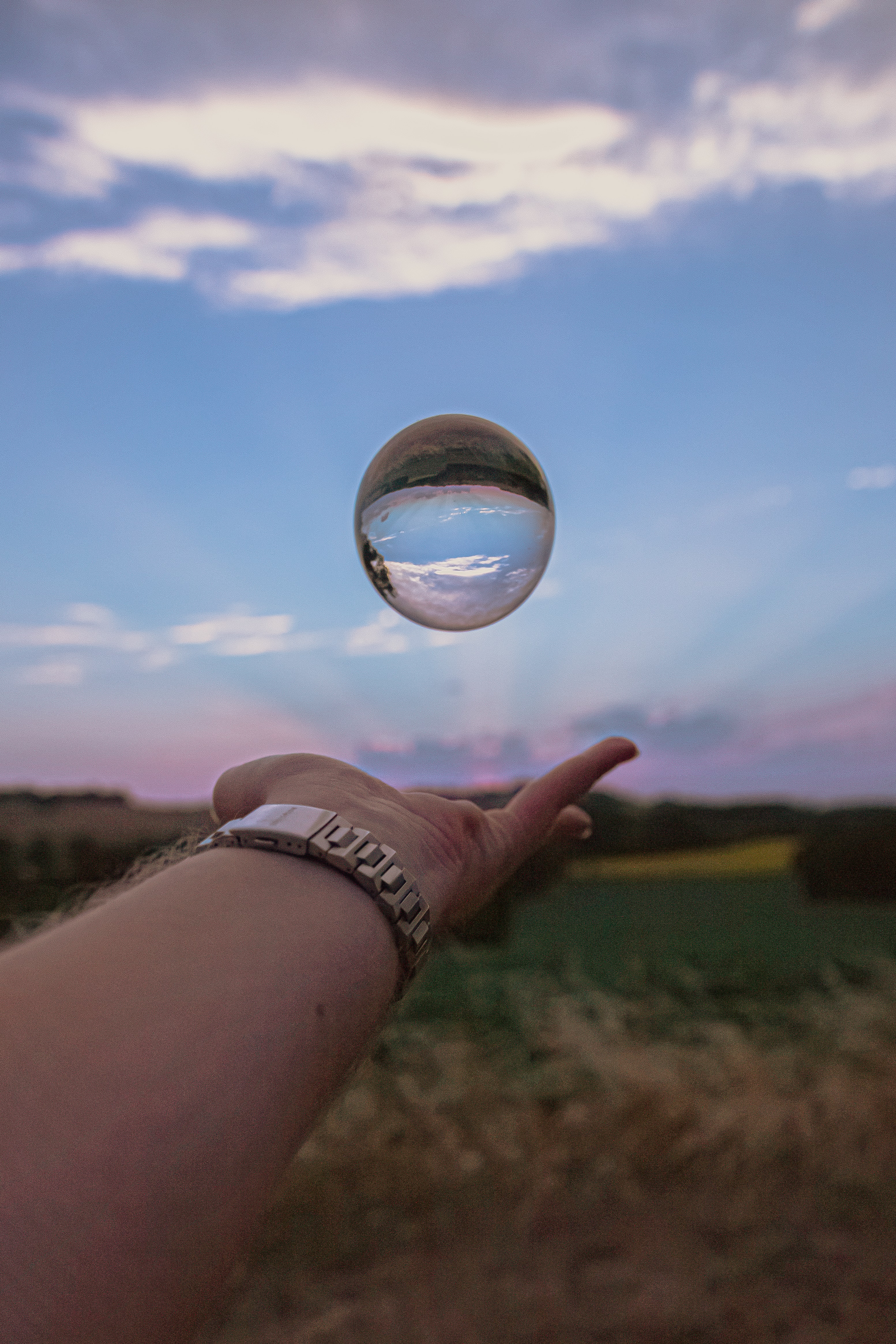 Free download wallpaper Sky, Reflection, Miscellanea, Miscellaneous, Ball, Hand, Clock on your PC desktop