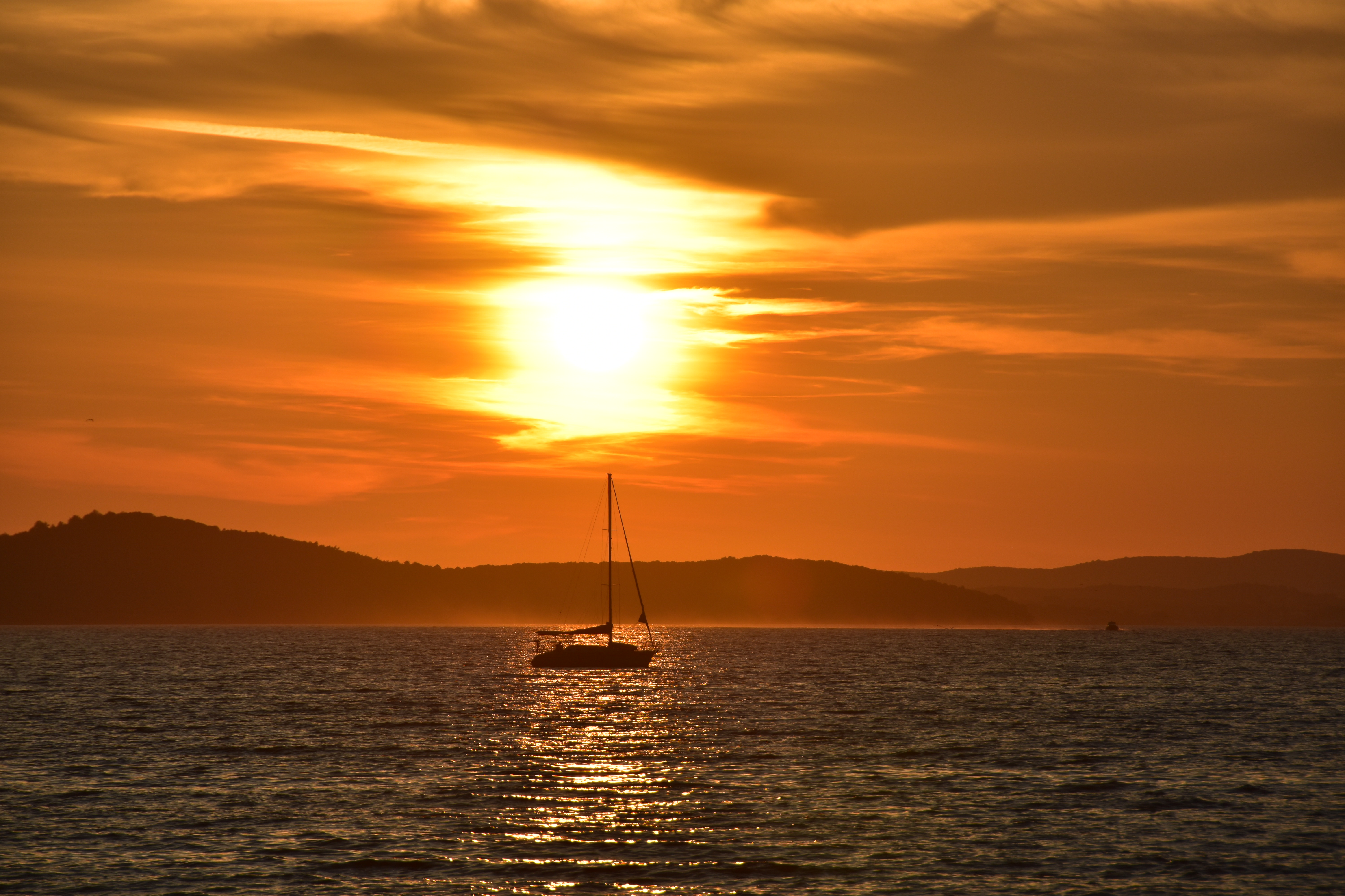 Download mobile wallpaper Glare, Sailfish, Sea, Nature, Sunset, Boat, Sailboat for free.