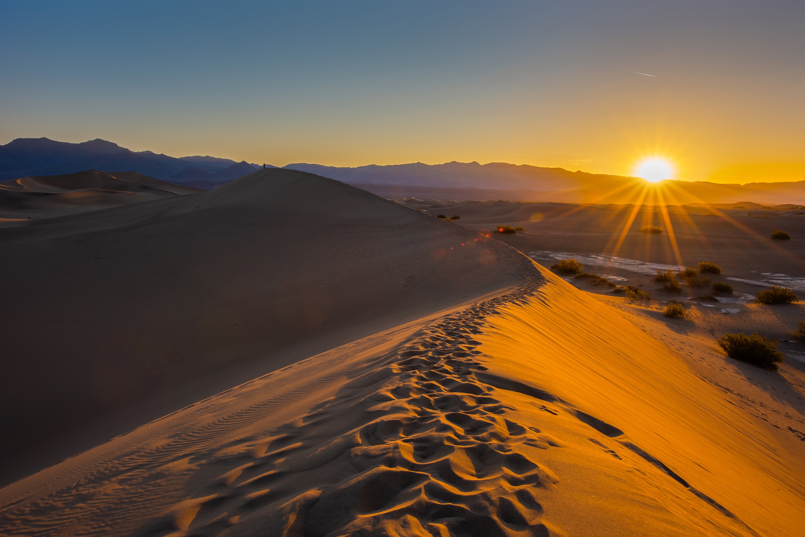 Download mobile wallpaper Nature, Sky, Sun, Sand, Desert, Sunrise, Earth, Dune, Sunbeam for free.
