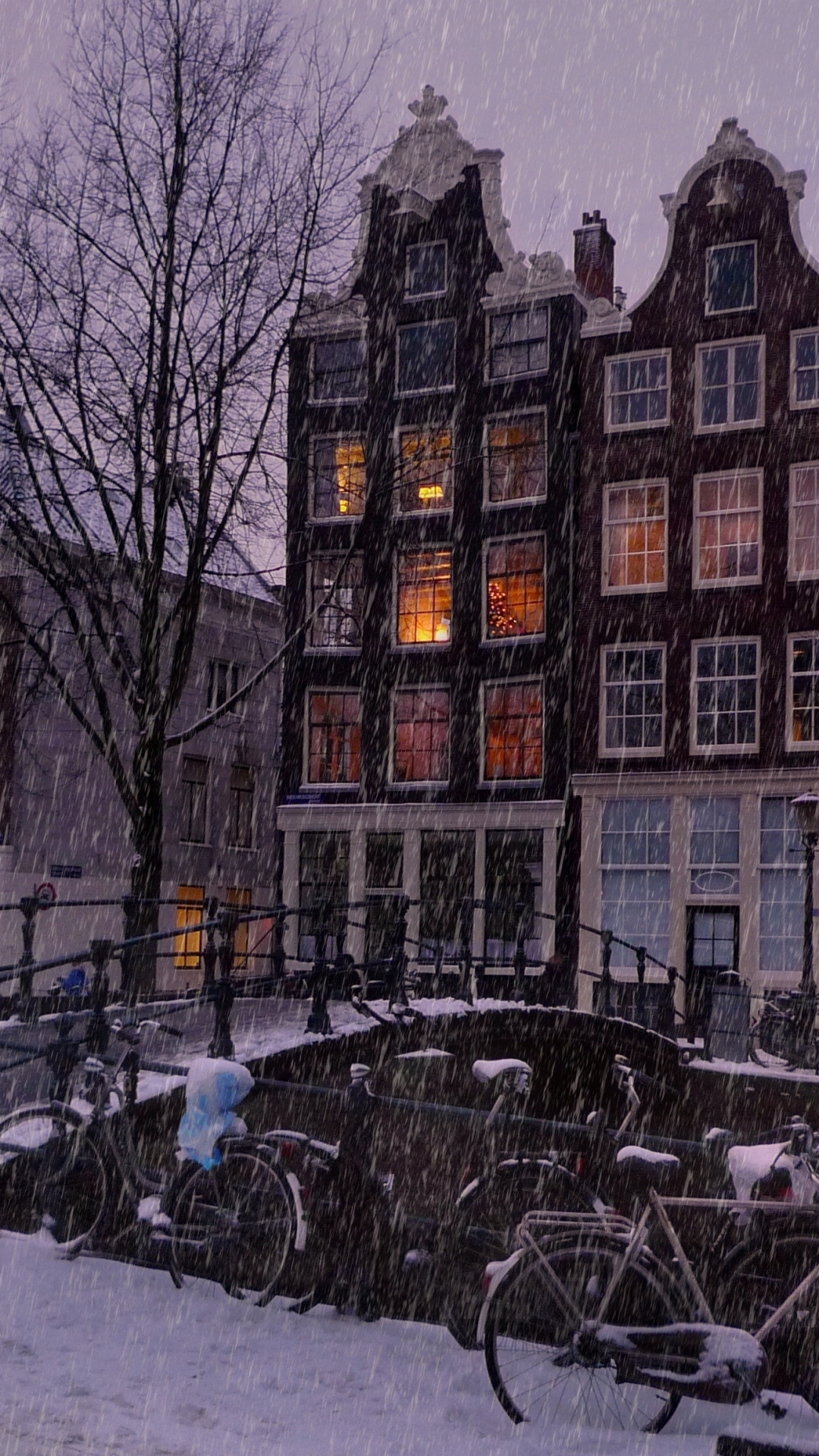 Скачать картинку Города, Зима, Снег, Дом, Вечер, Велосипед, Снегопад, Амстердам, Сделано Человеком в телефон бесплатно.