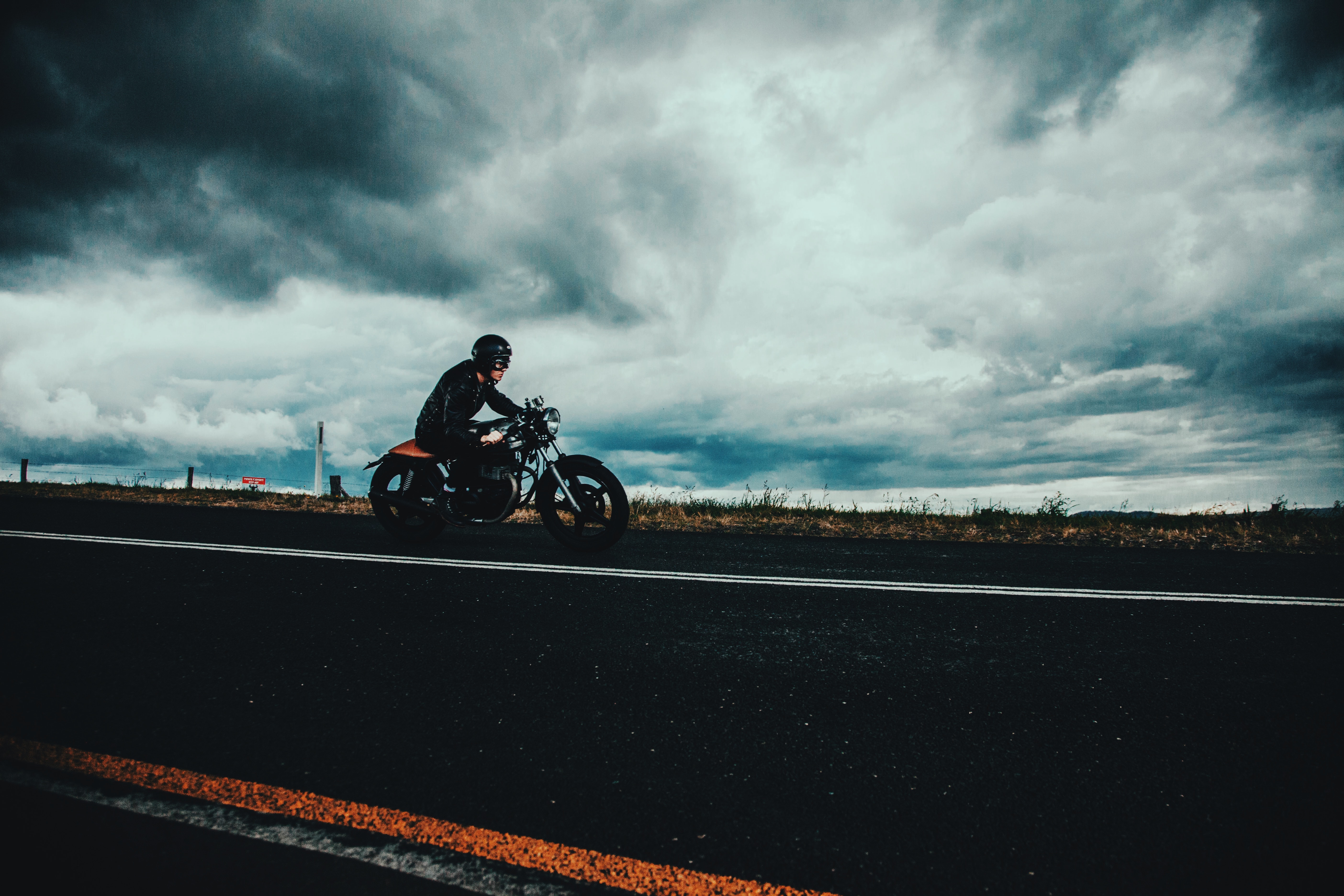 Mobile wallpaper motorcyclist, clouds, motorcycles, road, markup, asphalt, helmet, mainly cloudy, overcast