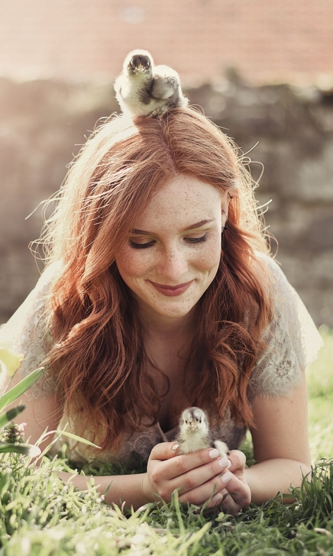 Download mobile wallpaper Grass, Smile, Redhead, Mood, Sunny, Chick, Model, Women, Freckles, Baby Animal, Lying Down for free.
