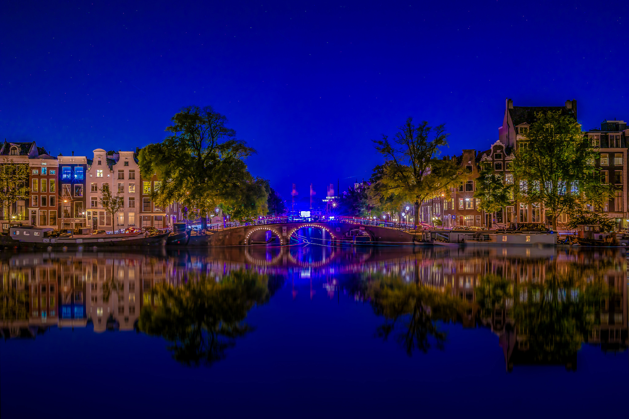 Free download wallpaper Cities, Night, City, Building, Reflection, Bridge, River, Netherlands, Amsterdam, Man Made on your PC desktop