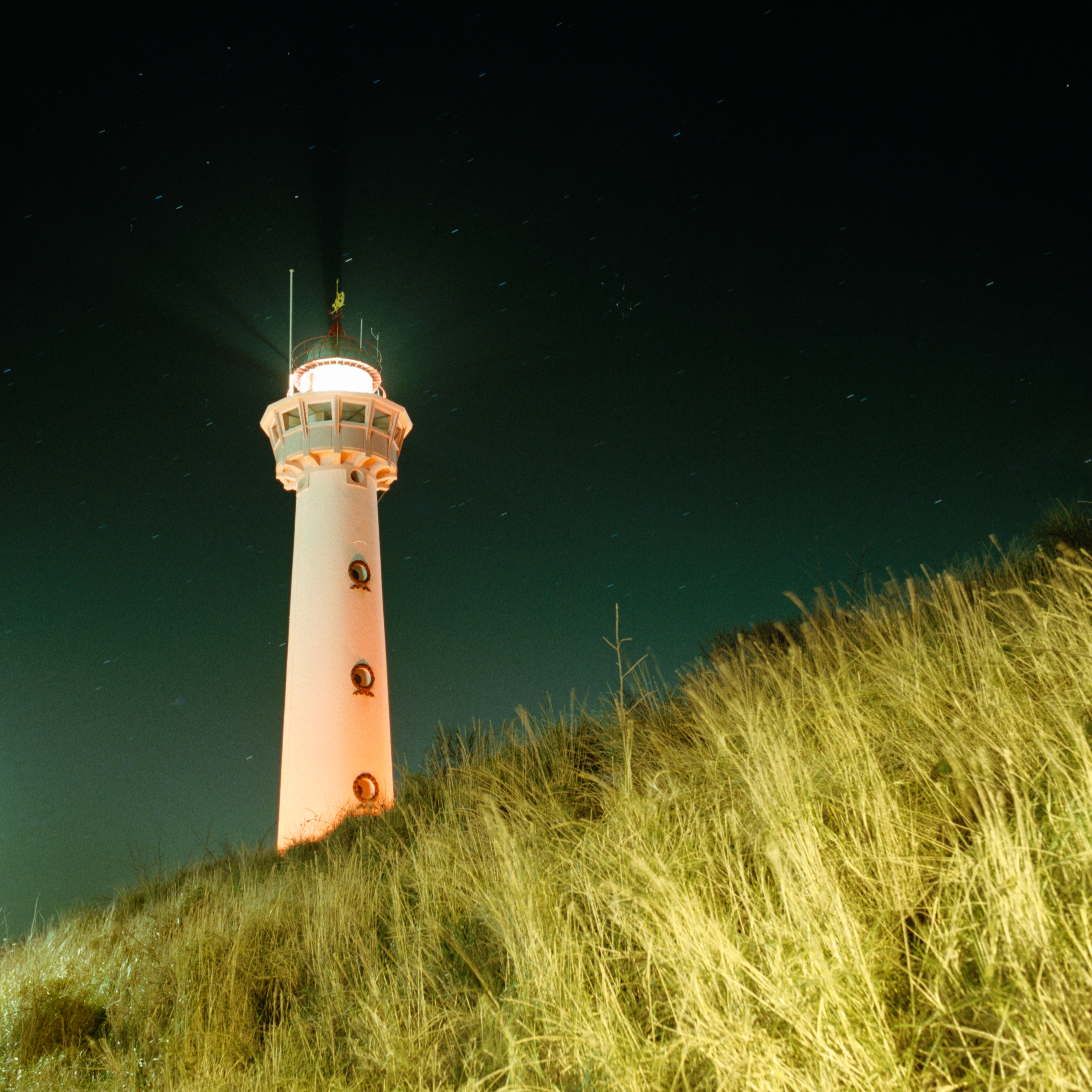 Download mobile wallpaper Grass, Building, Light, Nature, Lighthouse, Night, Shine for free.