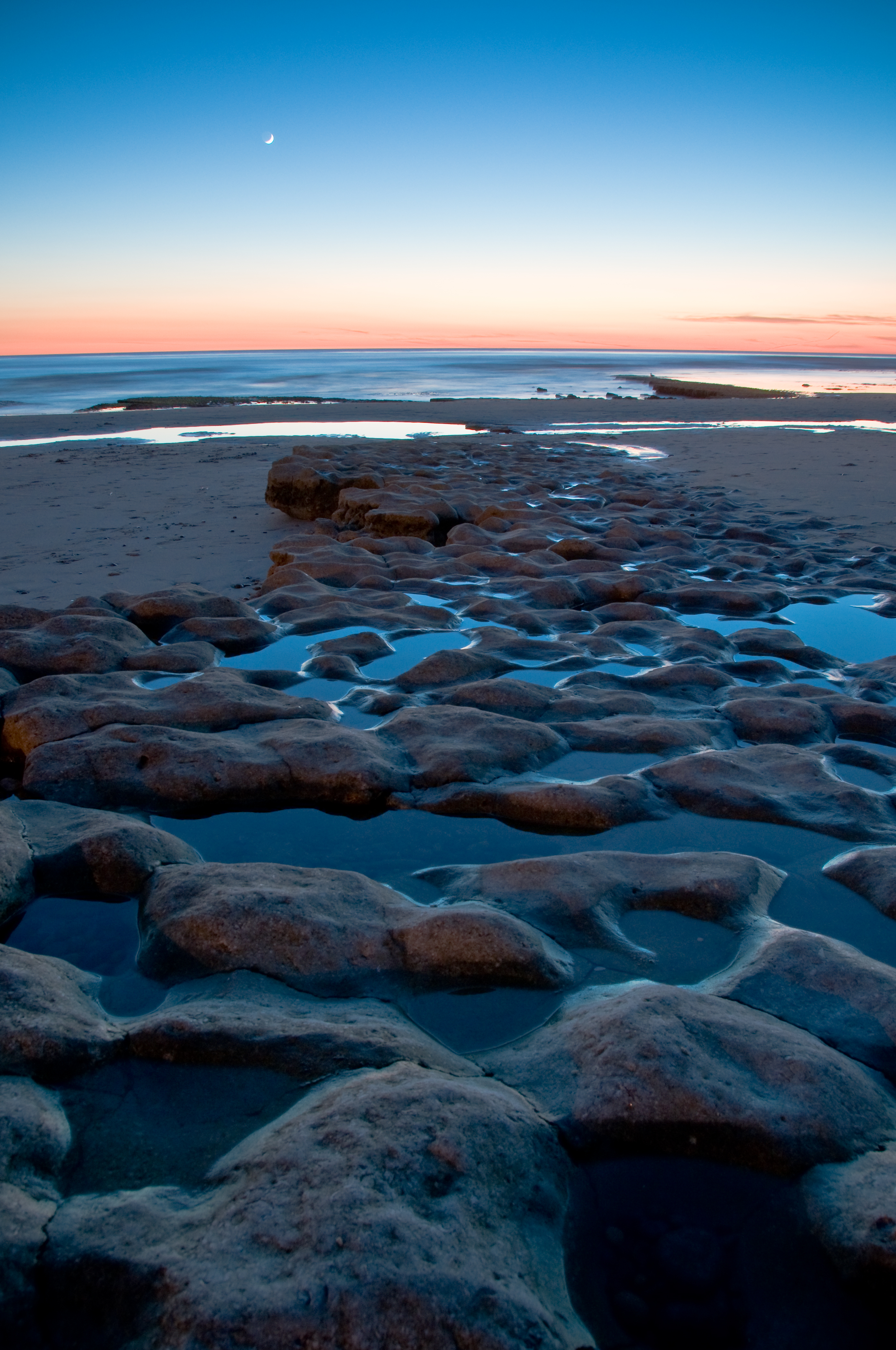 Download mobile wallpaper Shore, Bank, Stones, Horizon, Sand, Nature, Sea, Sunset for free.