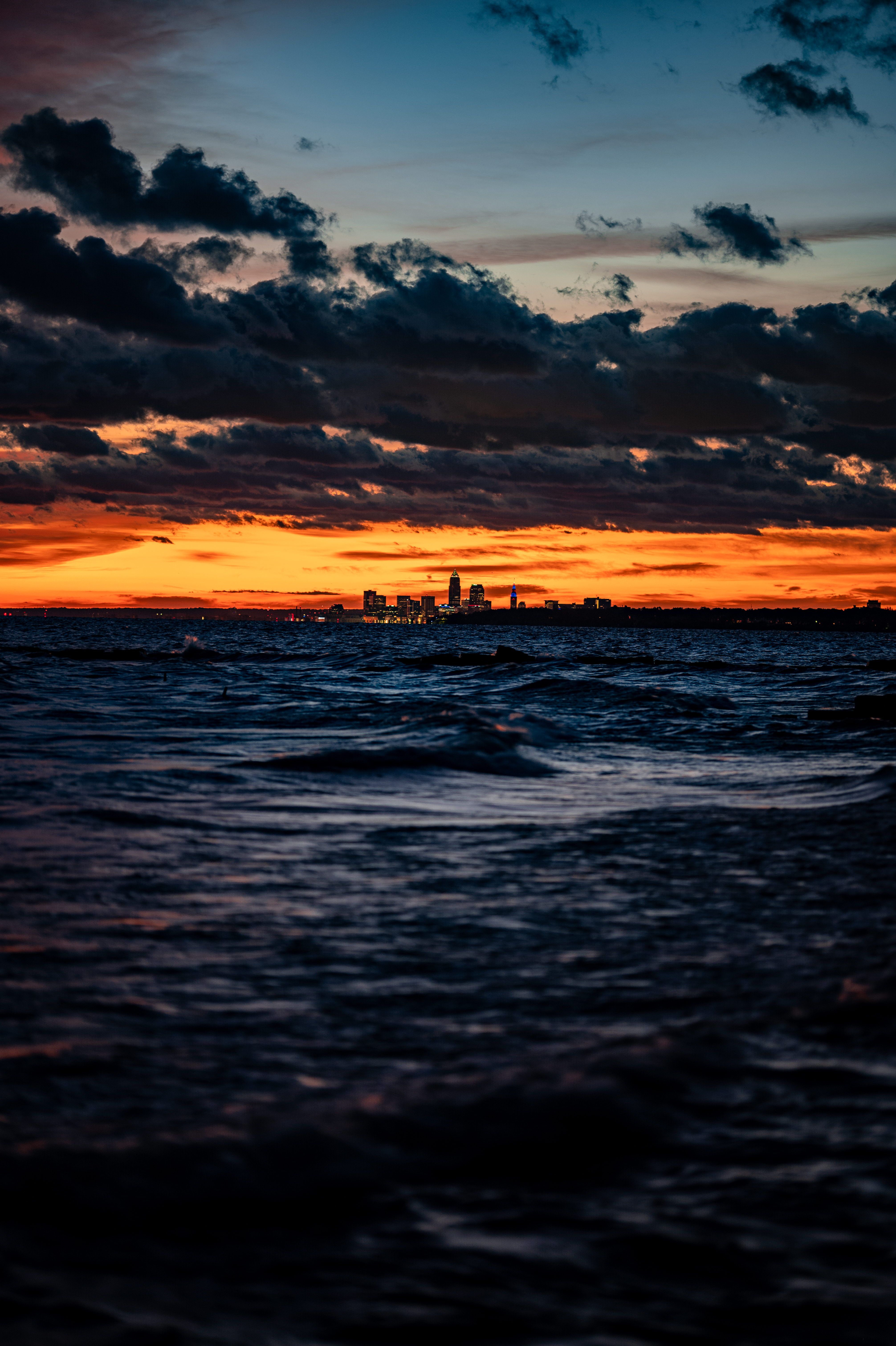 Download mobile wallpaper City, Waves, Sunset, Horizon, Sea, Nature for free.
