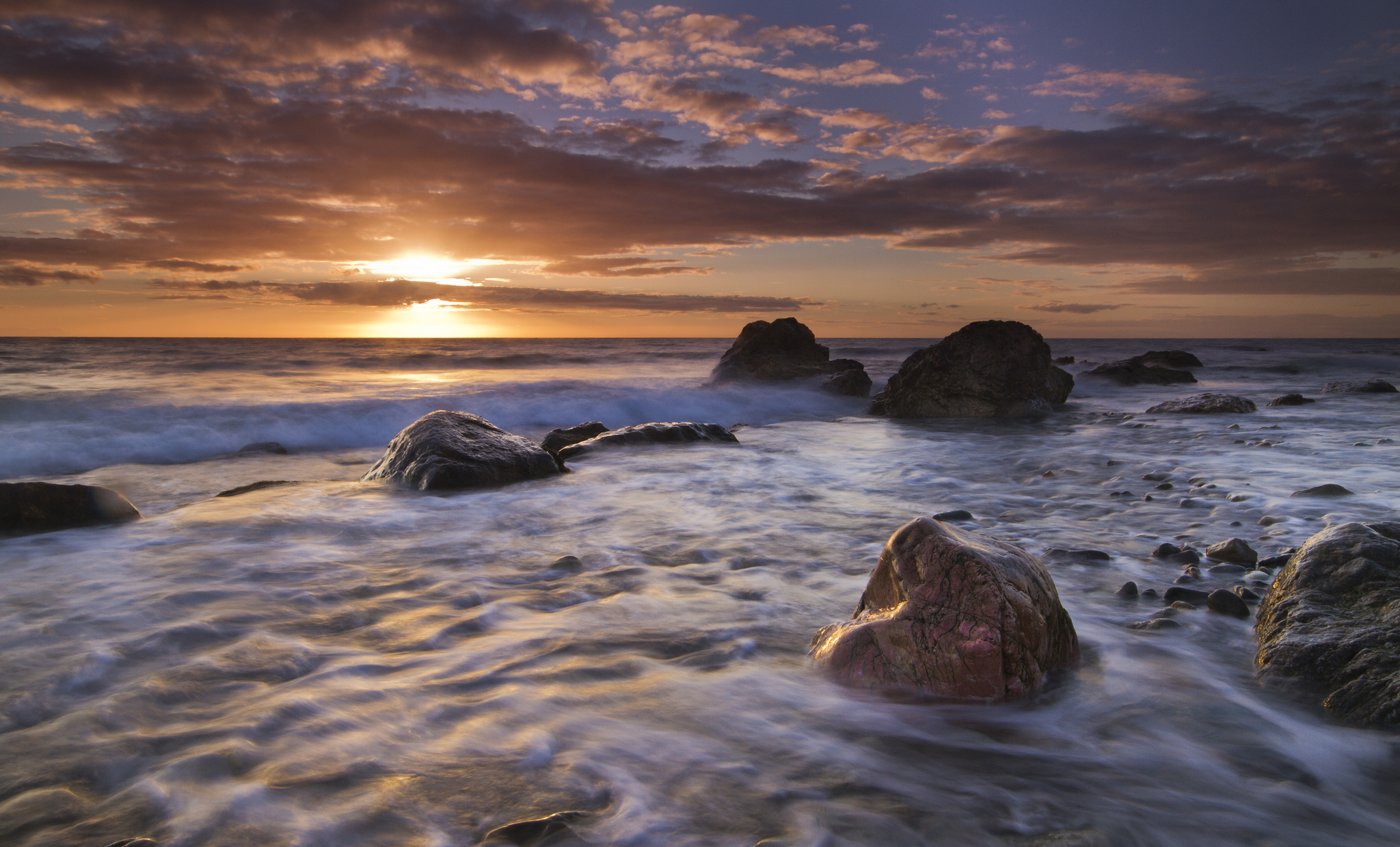 Скачать картинку Закат, Море, Камень, Уэльс, Англия, Земля/природа, Морской Пейзаж в телефон бесплатно.