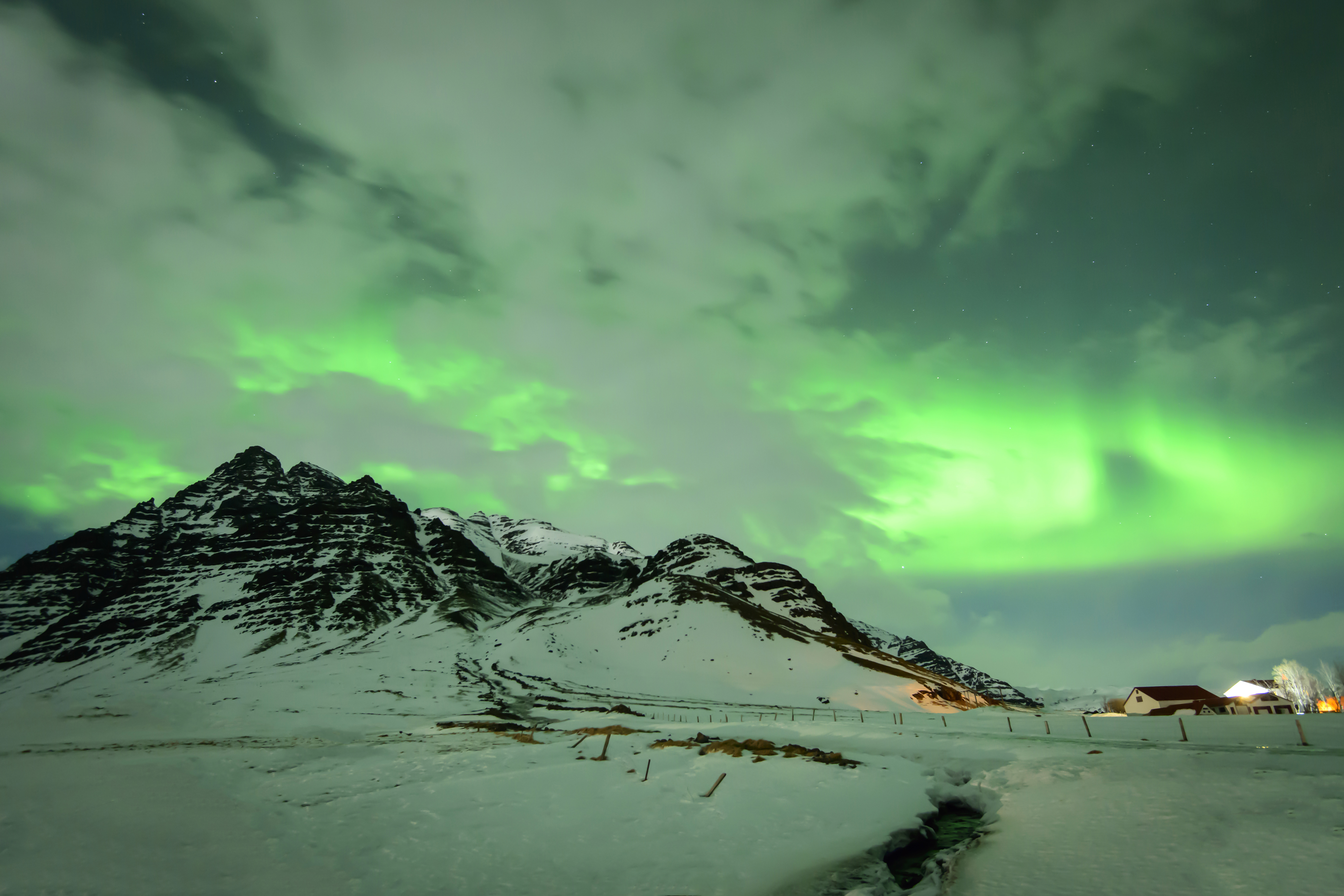 Скачать картинку Снег, Гора, Дом, Северное Сияние, Исландия, Земля/природа в телефон бесплатно.