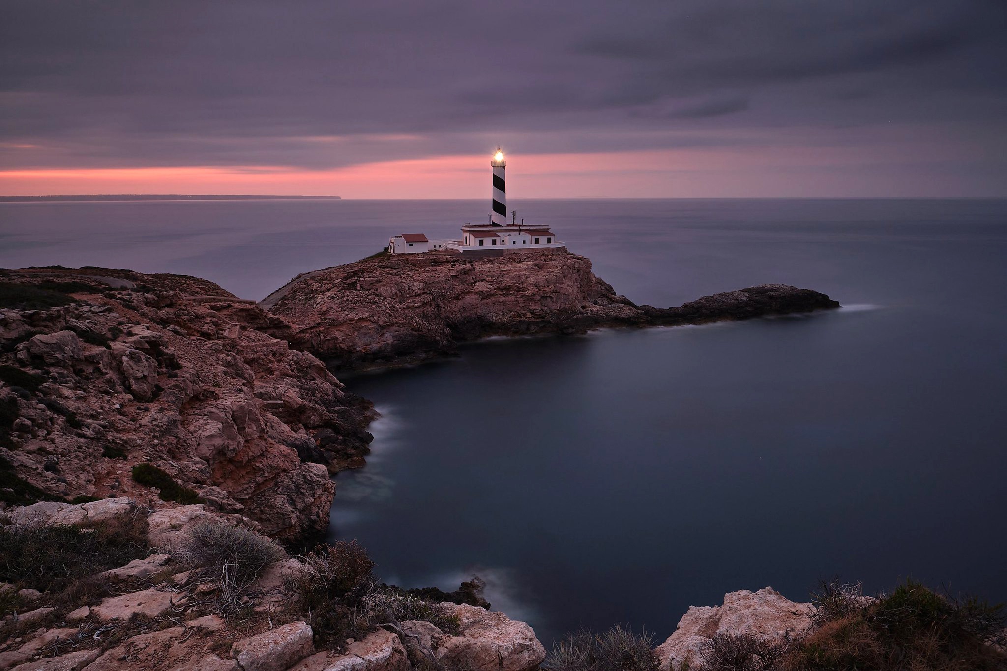 Handy-Wallpaper Horizont, Küste, Leuchtturm, Bucht, Spanien, Meer, Sonnenuntergang, Menschengemacht kostenlos herunterladen.