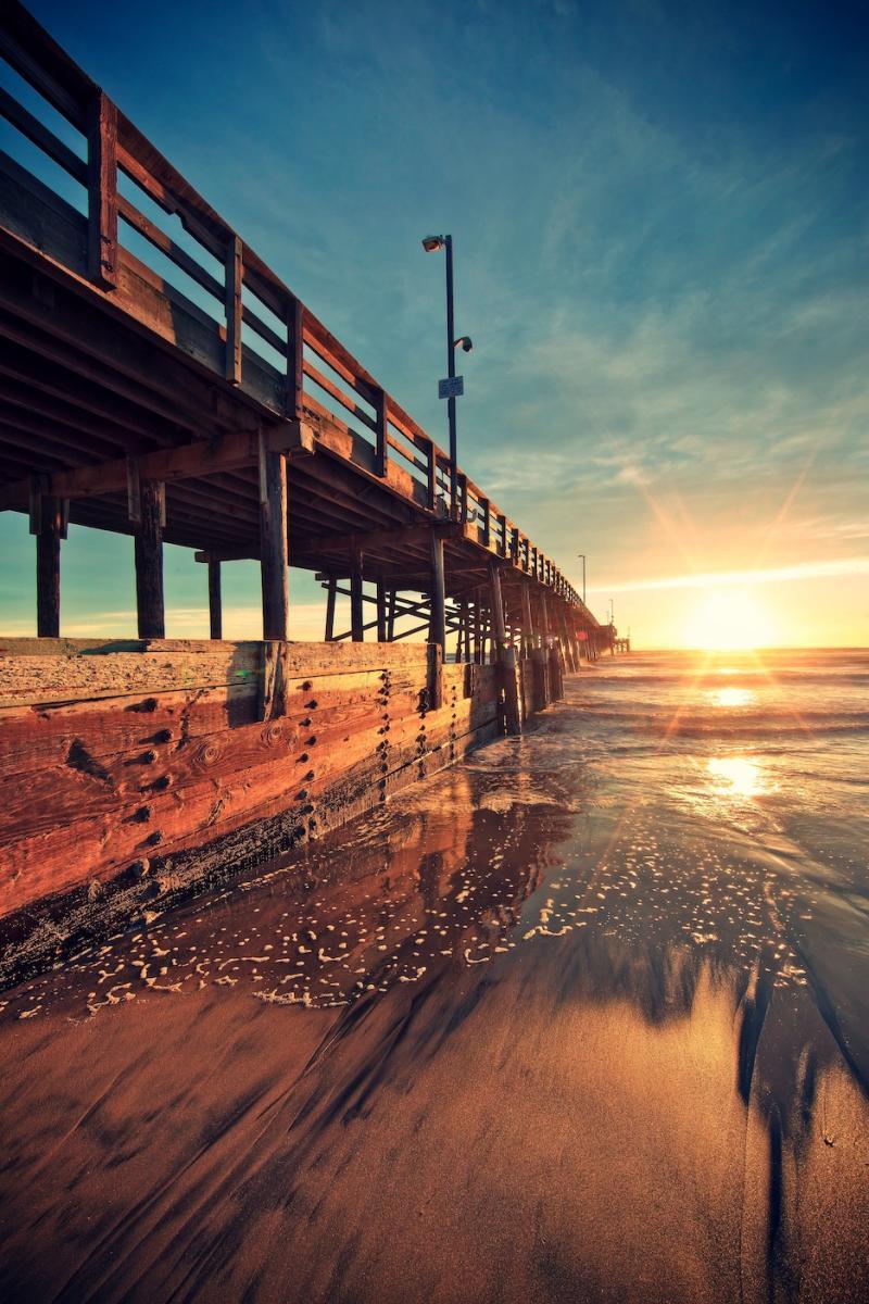 Download mobile wallpaper Sunset, Bridges, Sun, Landscape, Sea for free.