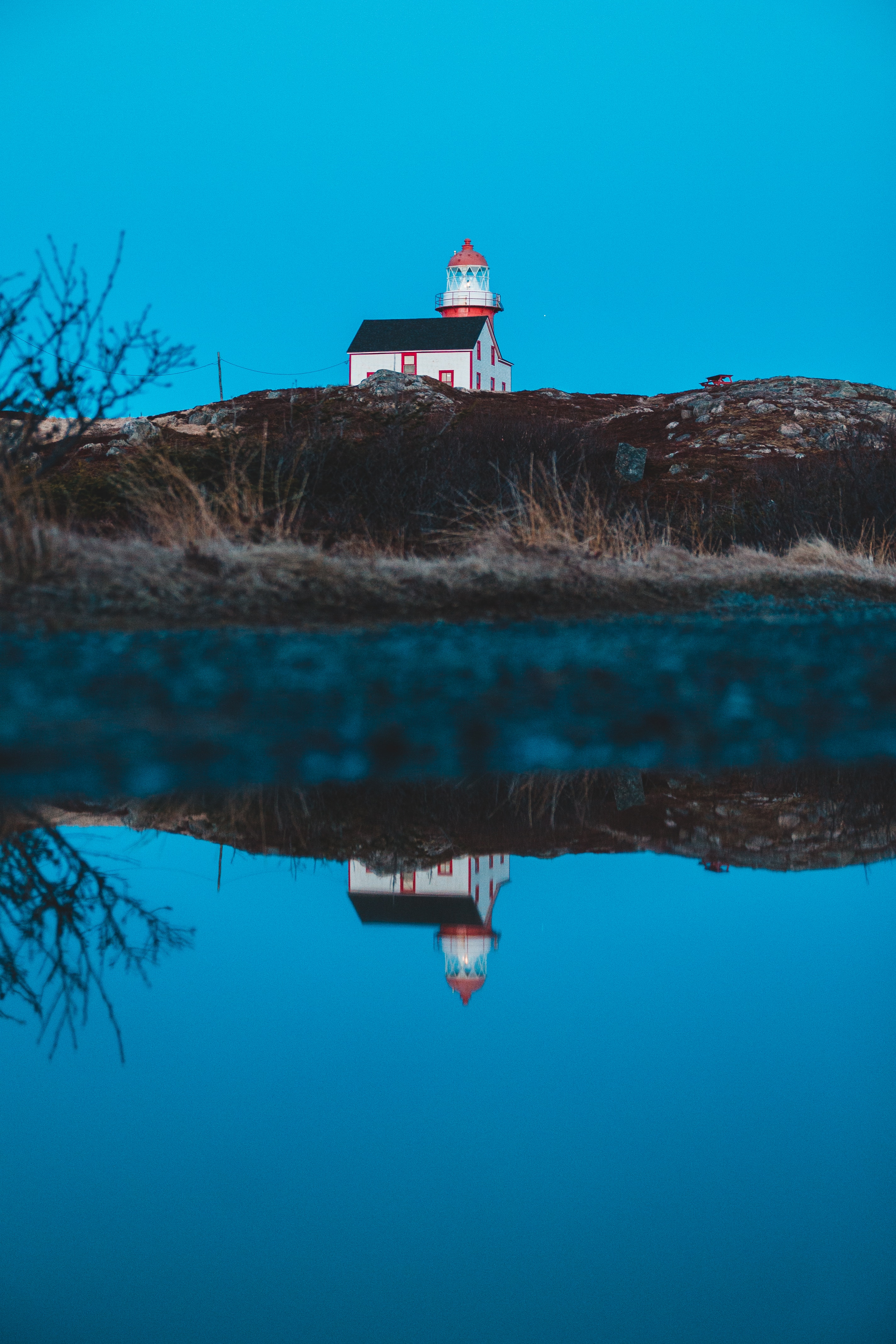 Download mobile wallpaper Reflection, Hill, Miscellaneous, Building, Water, Lighthouse, Miscellanea for free.