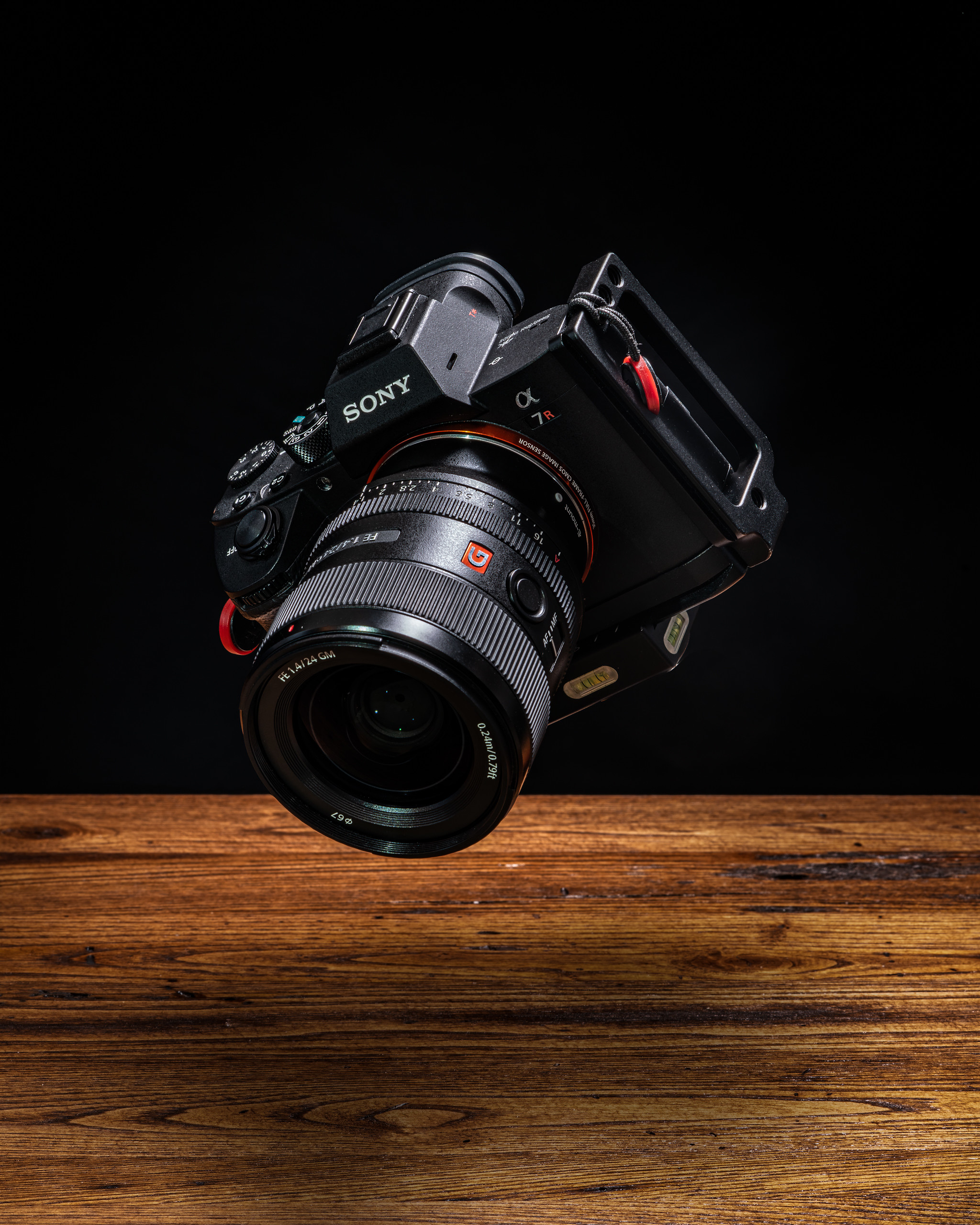 89917 скачать картинку объектив, темные, техника, фотоаппарат, поверхность, левитация - обои и заставки бесплатно