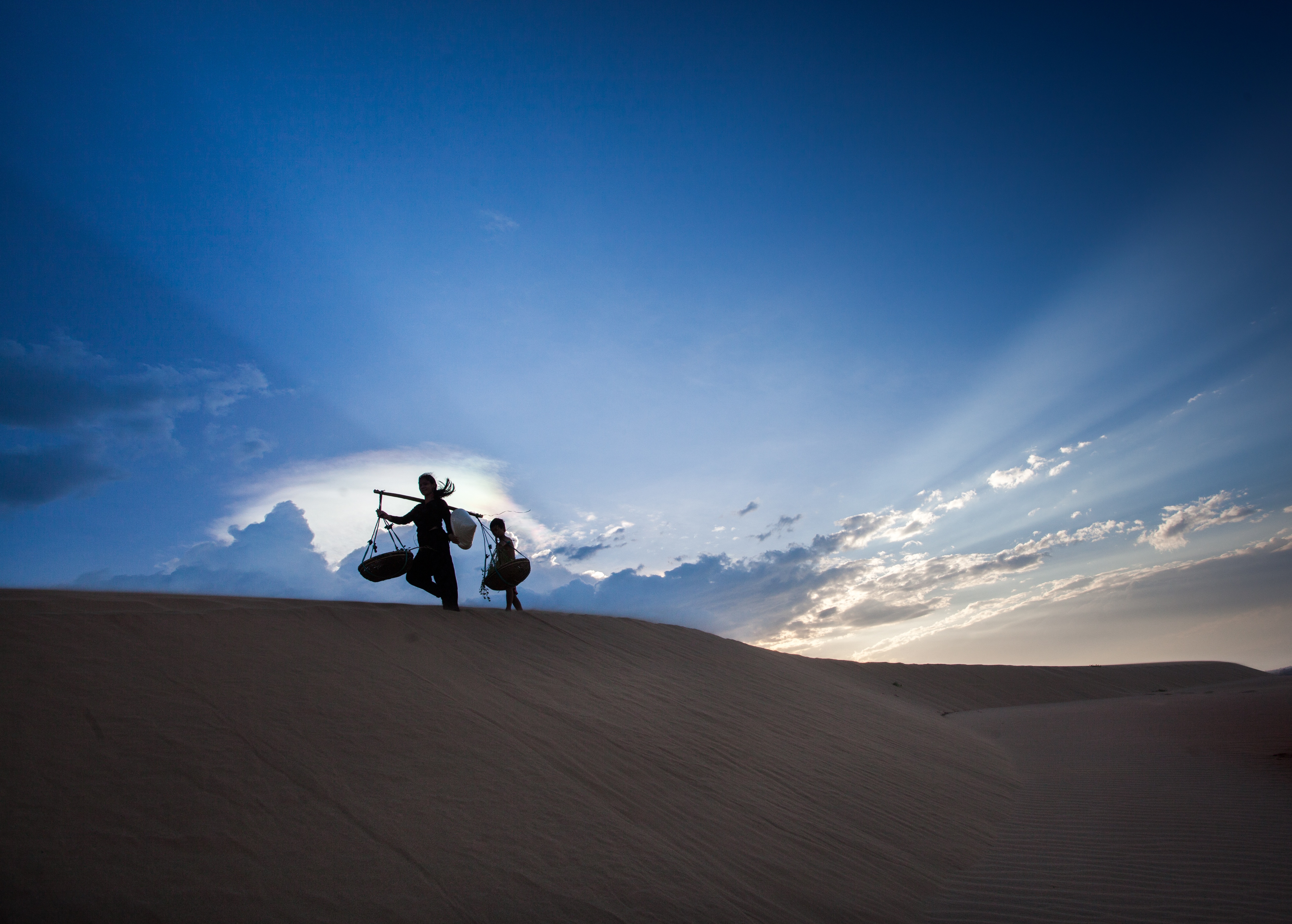 Download mobile wallpaper People, Sky, Sand, Desert, Silhouette, Hill, Photography, Sunbeam for free.