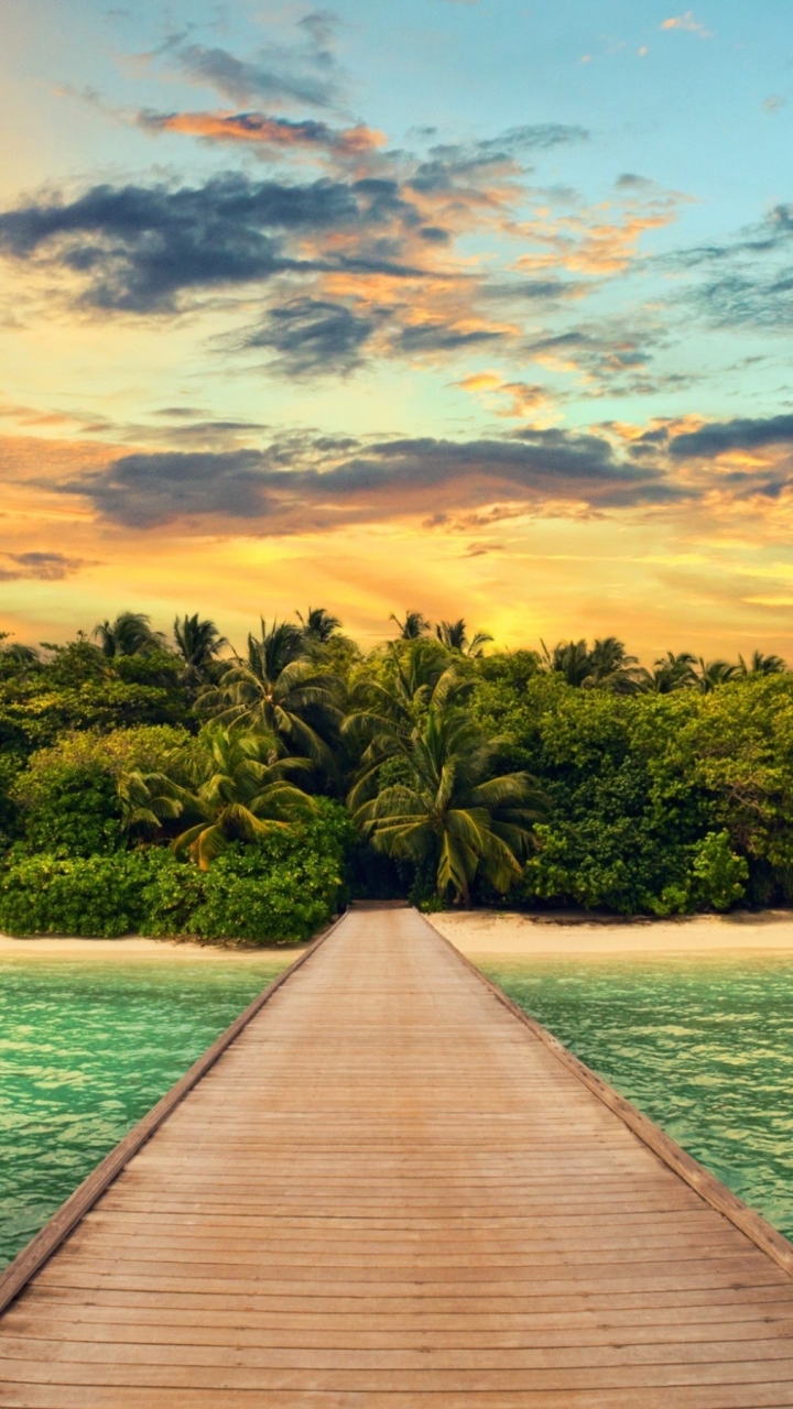Download mobile wallpaper Sunset, Sea, Pier, Ocean, Earth, Tropics, Island, Lagoon, Tropical, Palm Tree for free.