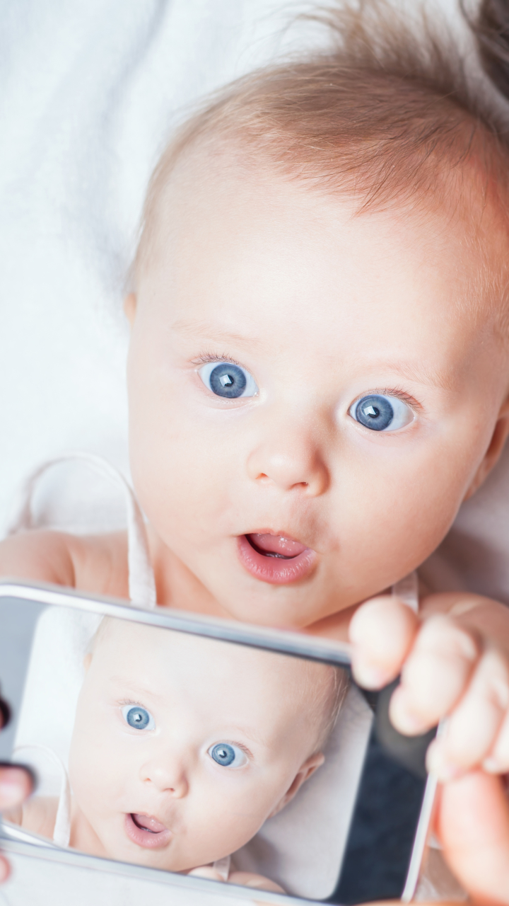 Скачать картинку Малыш, Улыбка, Телефон, Фотографии, Голубые Глаза в телефон бесплатно.